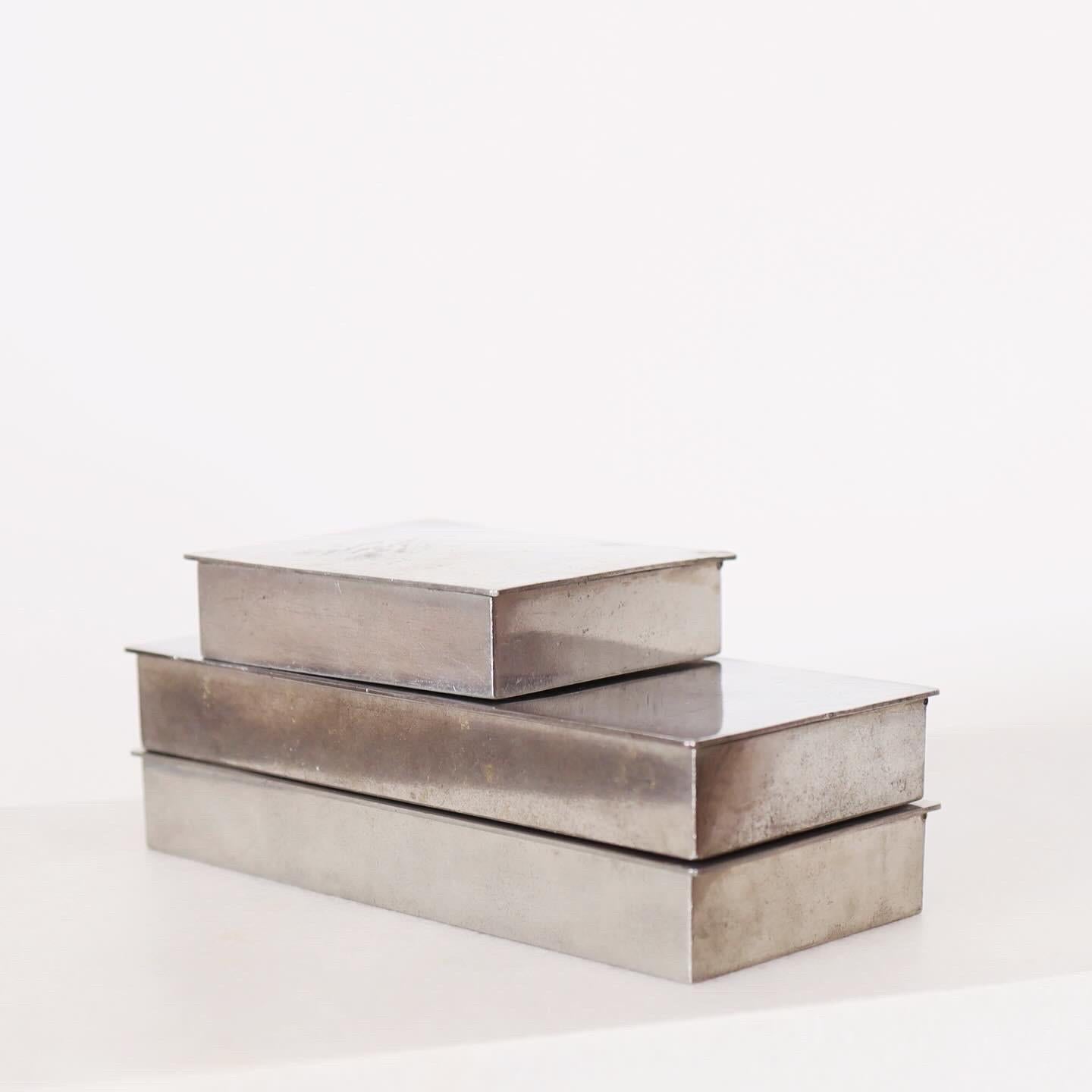 A trio of pewter boxes designed by Arne Erkers for Just Andersen in the 1950s.

* Three (3) lidded boxes in pewter with wooden inner boxes. Originally cigarette boxes.
* Designer: Arne Erkers
* Style: 2494 (2) & 2611 (1)
* Manufacturer: Just