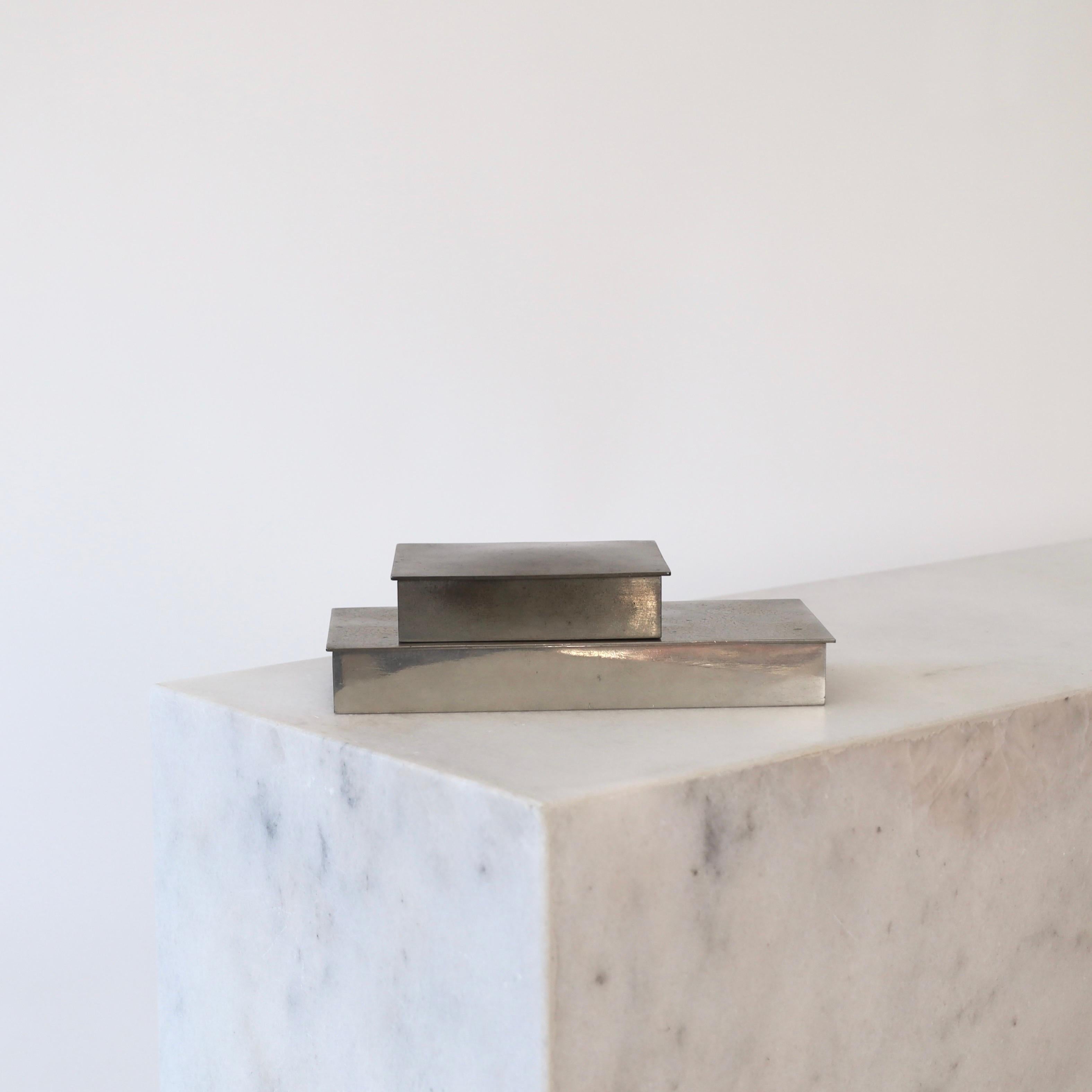 Set of Pewter Boxes designed by Arne Erkers for Just Andersen in the 1950s. An elegant set for a beautiful place.

* Two (2) lidded boxes in pewter with wooden inner boxes. Originally cigarette boxes.
* Designer: Arne Erkers
* Style: 2494 and 2611
*