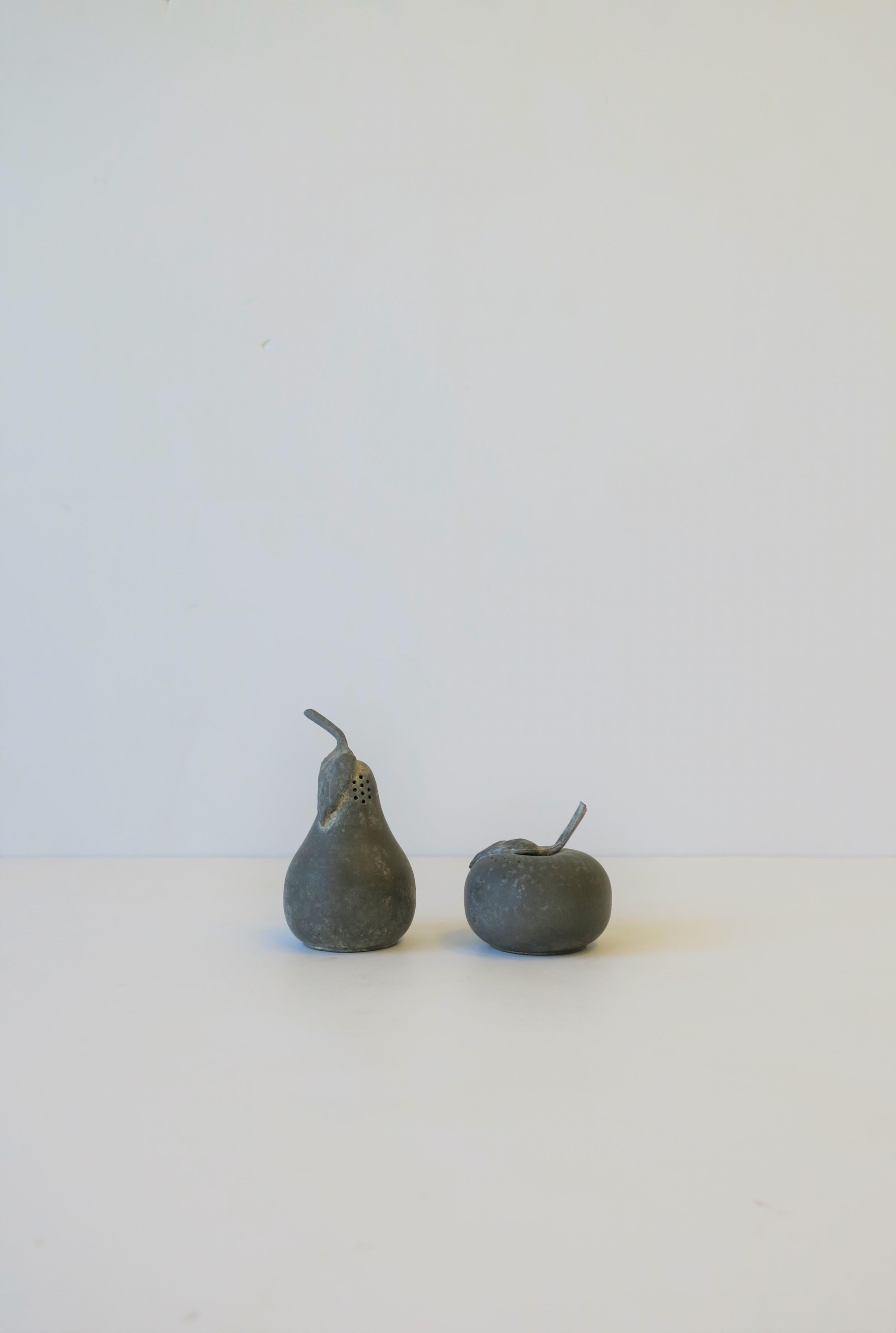 A set of weathered small pewter fruit (pear and apple) salt and pepper shakers, or, alternatively as decorative objects, circa mid-20th century. With maker's mark on bottom as shown in images #8 and 9.

Measurements L to R from image #1:
3