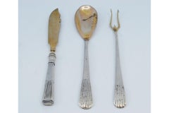 Set of pickle fork, butter knife and sauce spoon in gold with fluted handles