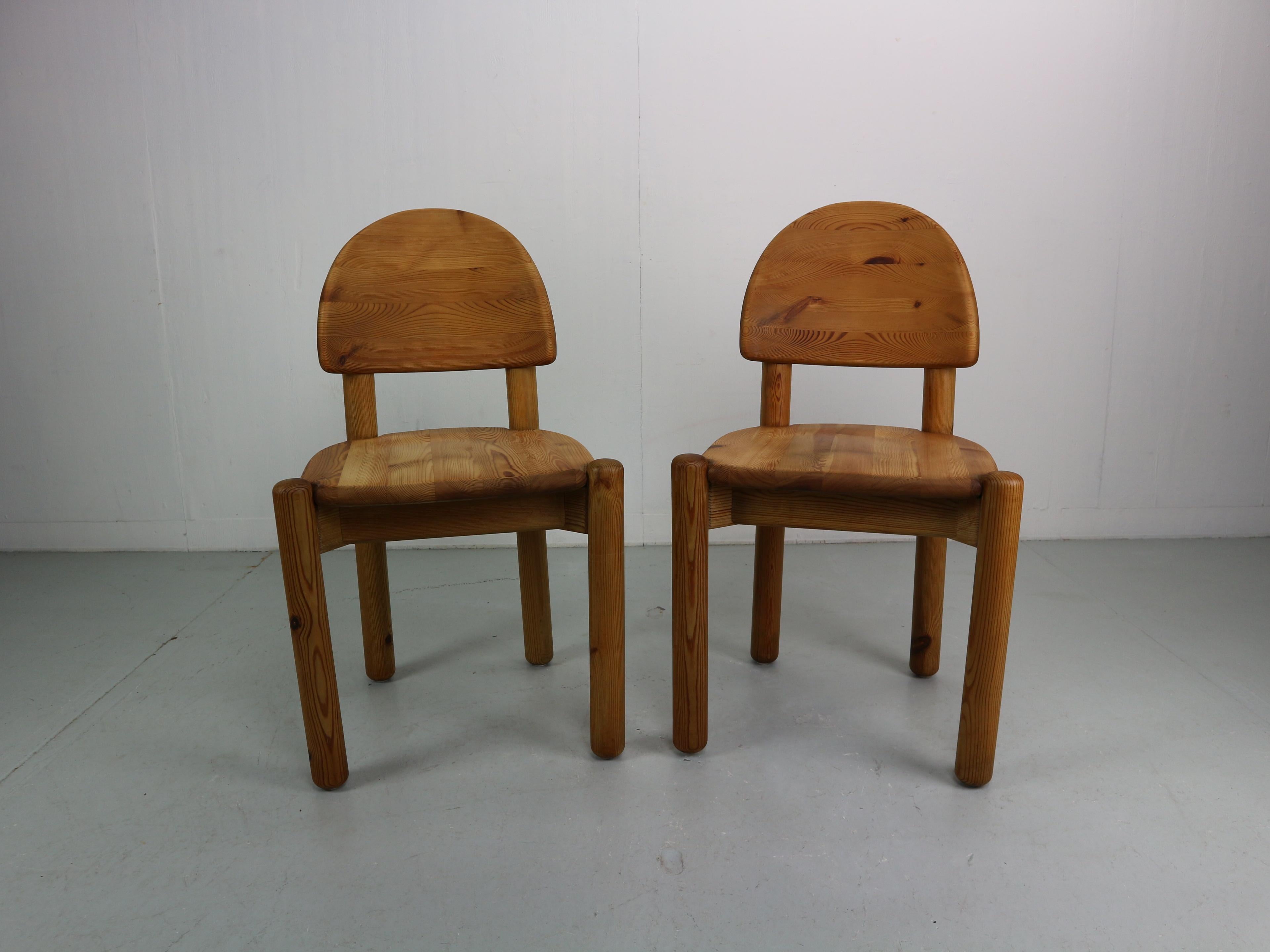 Set of two solid pine wood chairs in used condition. Designed by Rainer Daumiller and manufactured by Hirtshals Savvaerk in the 1970s. The chairs have a carved seat and backrest which give them a robust and organic appearance. The rustic pine wood
