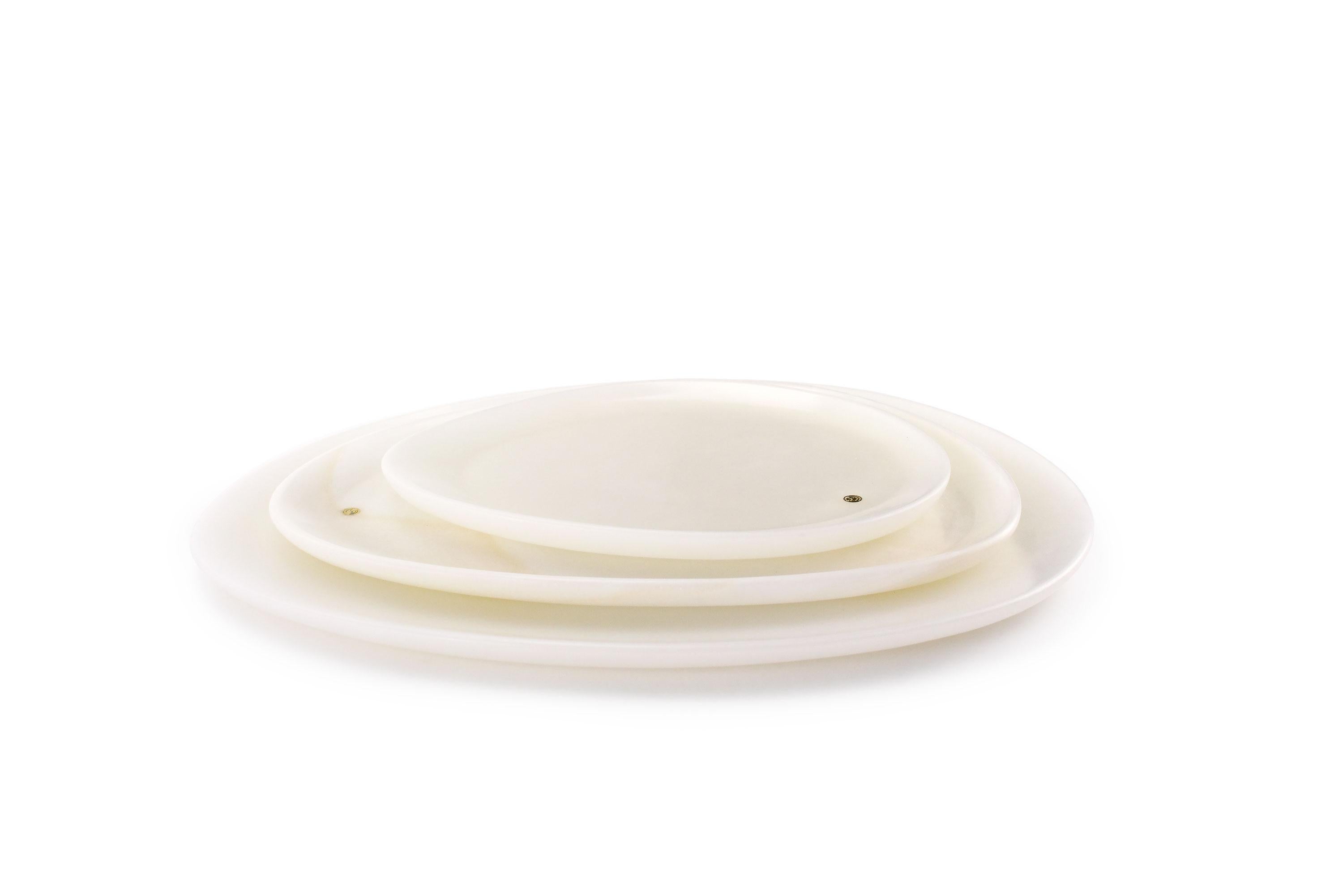 Hand carved presentation plates in white onyx. Multiple use as plates, platters and placers. The polished finishing underlines the transparency of the onyx making this a very precious object. 

Dimensions: Small - L24 W20 H1.8 cm, Medium - L30 W28