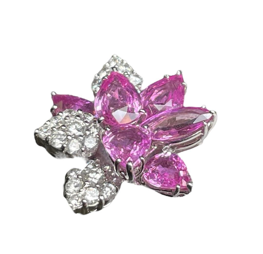 This is a set of a platinum cluster ring and dangle pair of earrings with natural pink sapphires and diamonds. The pink sapphires are depicting pear and marquise cuts. The round diamonds grain are setting in a pear shaped cluster with the same