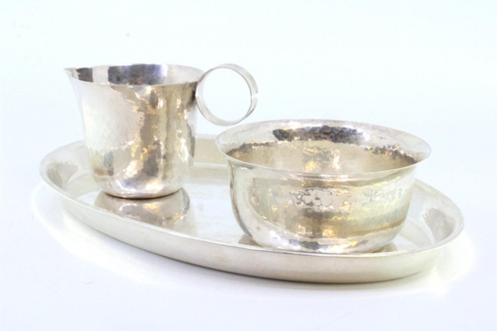 Description: Set of serving tray with cup and bowl in hammered silver. Metal: Silver. Origin: German. Brand: FWOE. Weight: 249.53g (Set of serving tray, cup and bowl). Dimensions: Tray 21.5x14.2. Content: 835/1000. Assay Mark: Yes. Additional