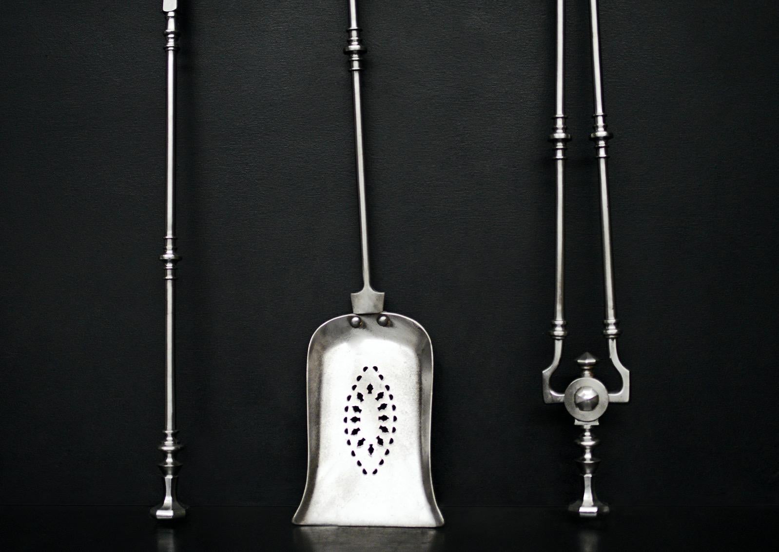 A set of polished steel firetools in the Georgian manner. The hexagonal handles with swells below. Pierced decorative pan. English, 19th century. 

Length:	740 mm      	29 ⅛