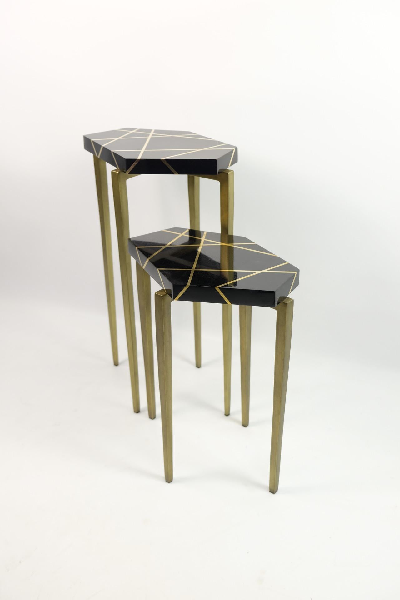 This futurist set of tables is made of polished black shell marquetry, with brass trims.

The top has a polygonal shape and the metal feet have an antique brass patina.

The tables are small and very versatile. It can be placed anywhere near a