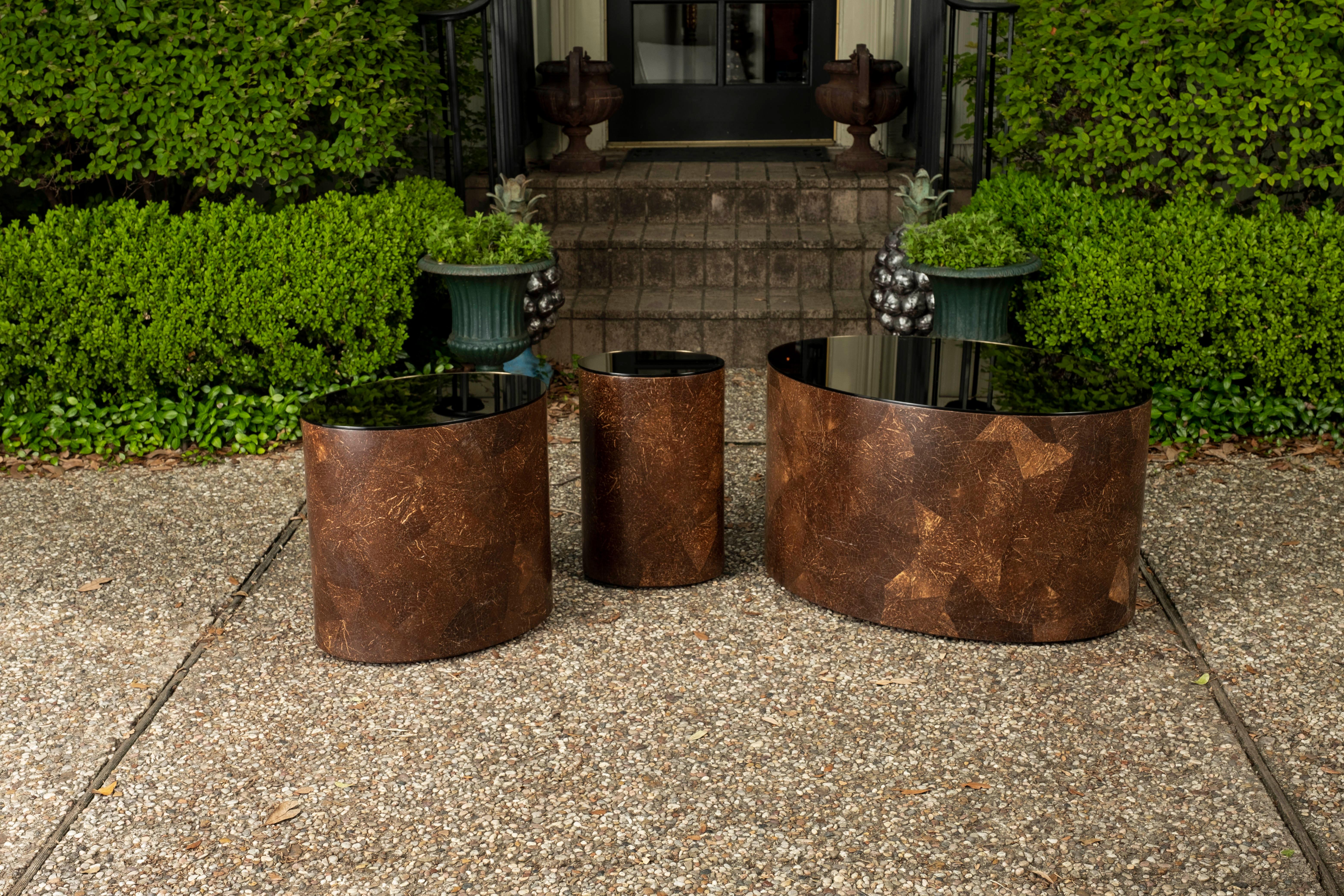 Set of post modern coconut shell tables. This handsome set consists of 3 mid-century oval coconut shell tables with bronze mirrored tops. This rare versatile set of vintage coconut shell tables could be used together to create an interesting