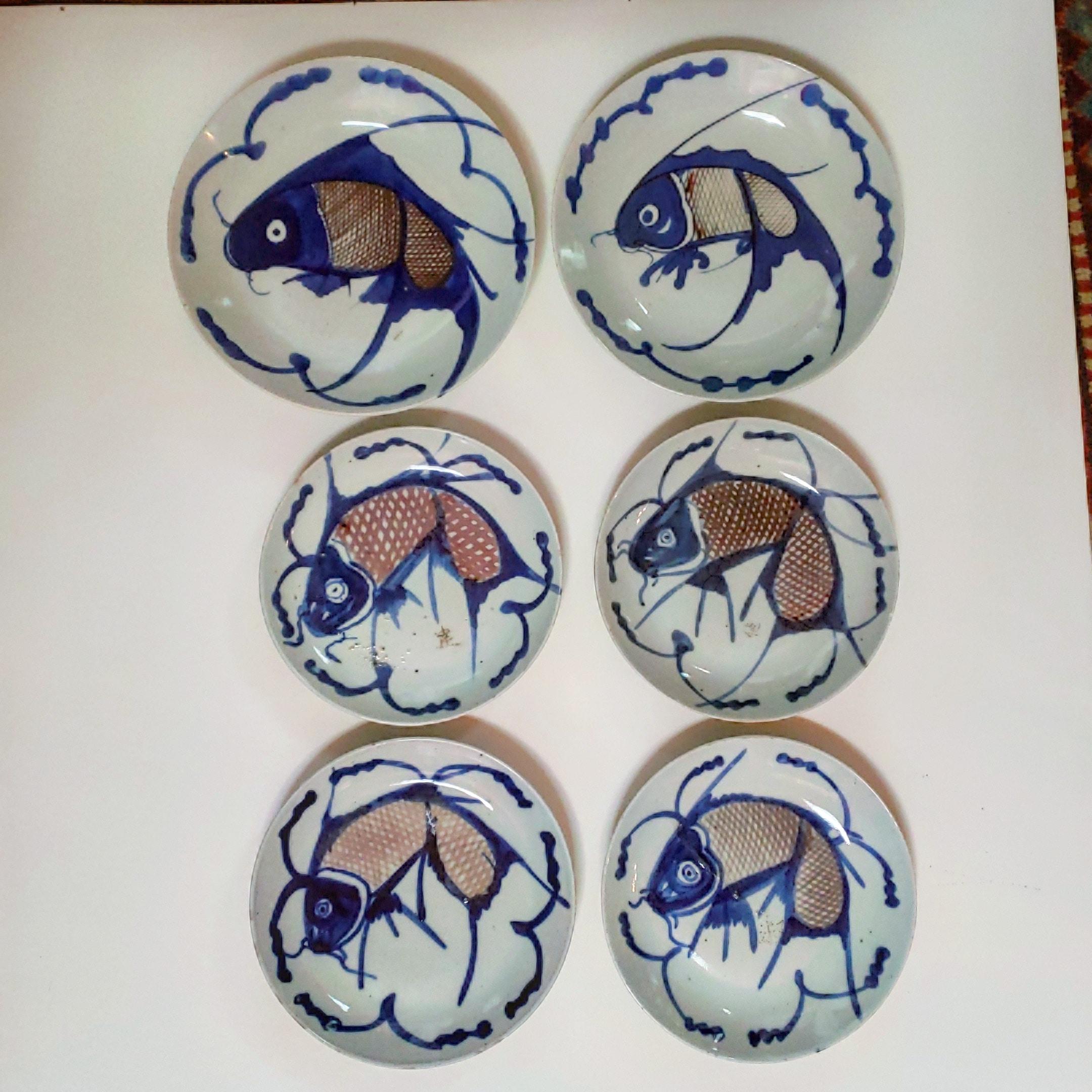 6 vividly decorated porcelain carp plates in blue and purple glaze on a blue-tinted clear glaze ground. These plates are were often seen on the tables of rural China. These bowl-like plates exhibit arrestingly bold stylized leaping carp, energized