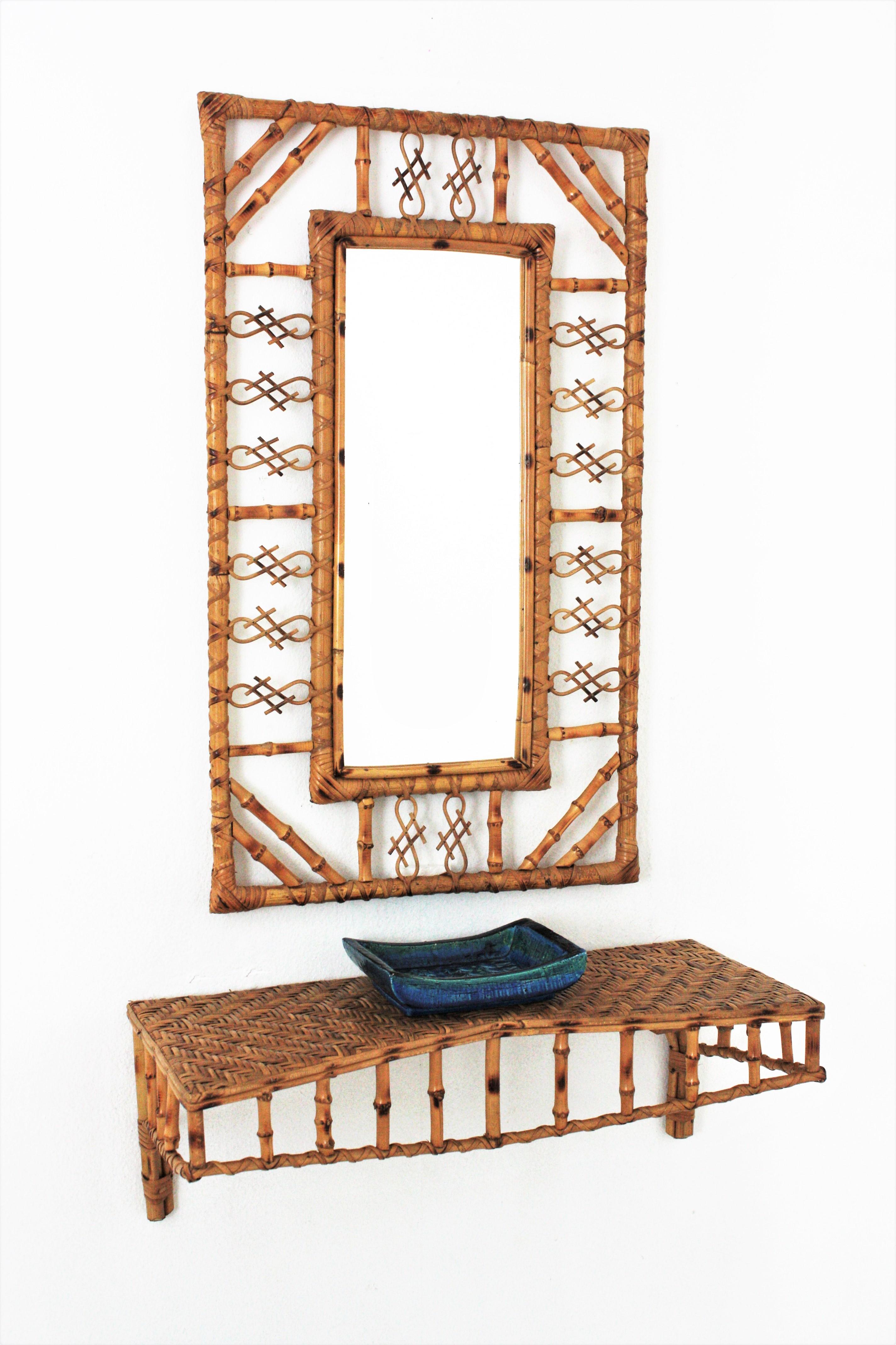 Eye-catching set of rattan and bamboo rectangular mirror with floating console table / shelf, France, 1950s.
The mirror has chinoiserie and bamboo decorations on the frame and joining the corners. The wall console shelf has a structure made of