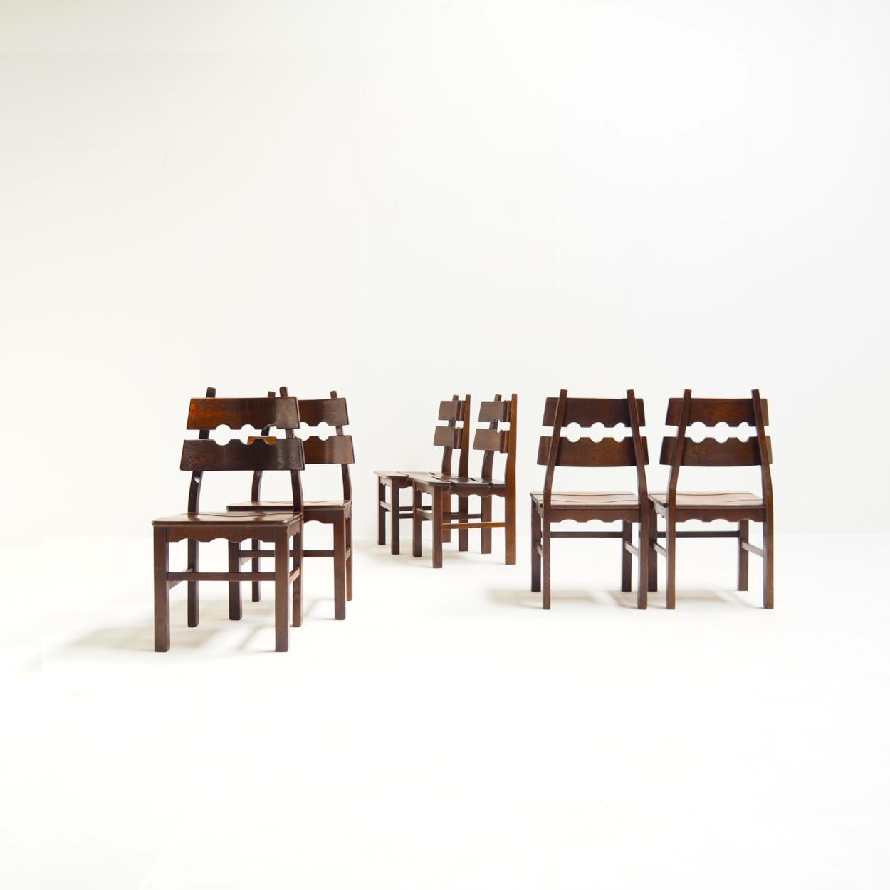 Rare ensemble de chaises de salle à manger attribué au designer danois Henning Kjaernulf pour Nyrup Møbelfabrik.

Les chaises ont de magnifiques dossiers en forme de rasoir et sont fabriquées en chêne massif teinté brun. Notez les pattes arrière