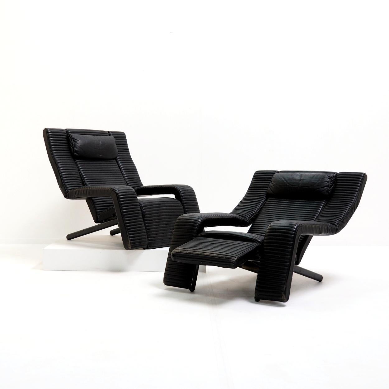 Set of postmodern adjustable lounge chairs designed in 1985 by Tittina Ammannati & Giampiero Vitteli. The seats are upholstered in stitched black leather with a sturdy metal structure that allows the seats to recline and have a footrest. The seats