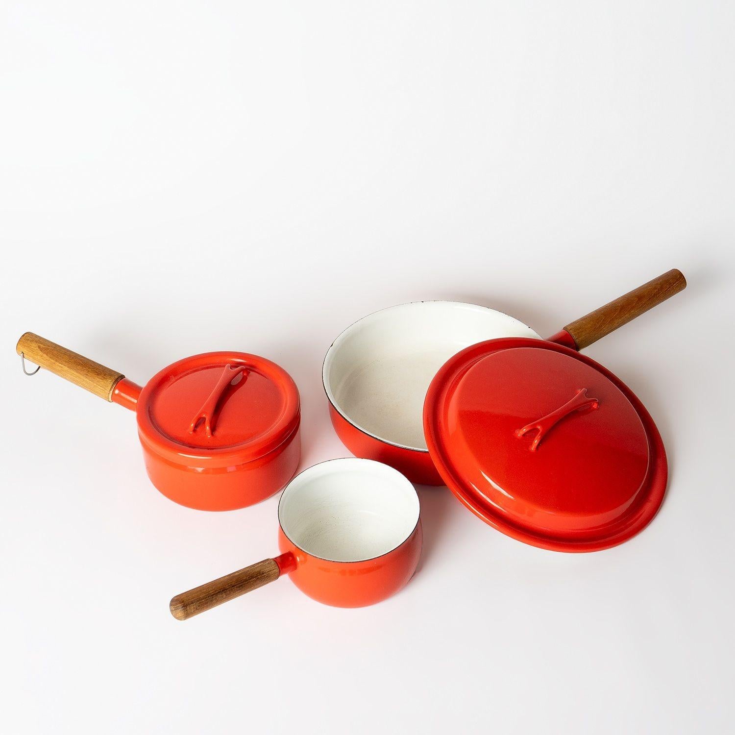 Vintage Mid-Century Scandinavian Cookware

A matching set of three saucepans. One large diameter shallow pan with lid. One medium-sized saucepan with a lid and a smaller saucepan (designed without a lid). All in red enamel with white enamel