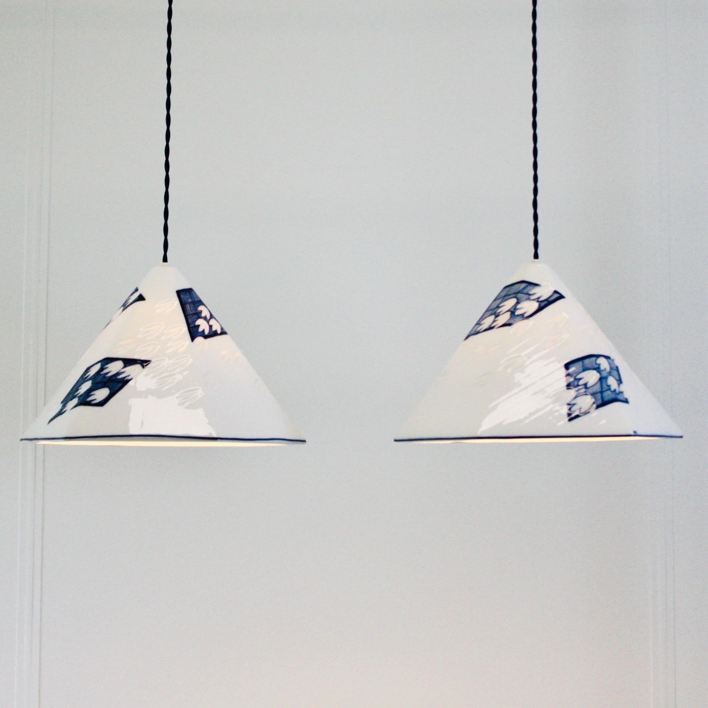 A set of Royal Copenhagen porcelain pendant lights by Anne Marie Trolle. The set is in excellent condition and presents a reinterpretation of the classic Royal Copenhagen art work. 

* A set of white 6-sided porcelain pendant lights with dark blue
