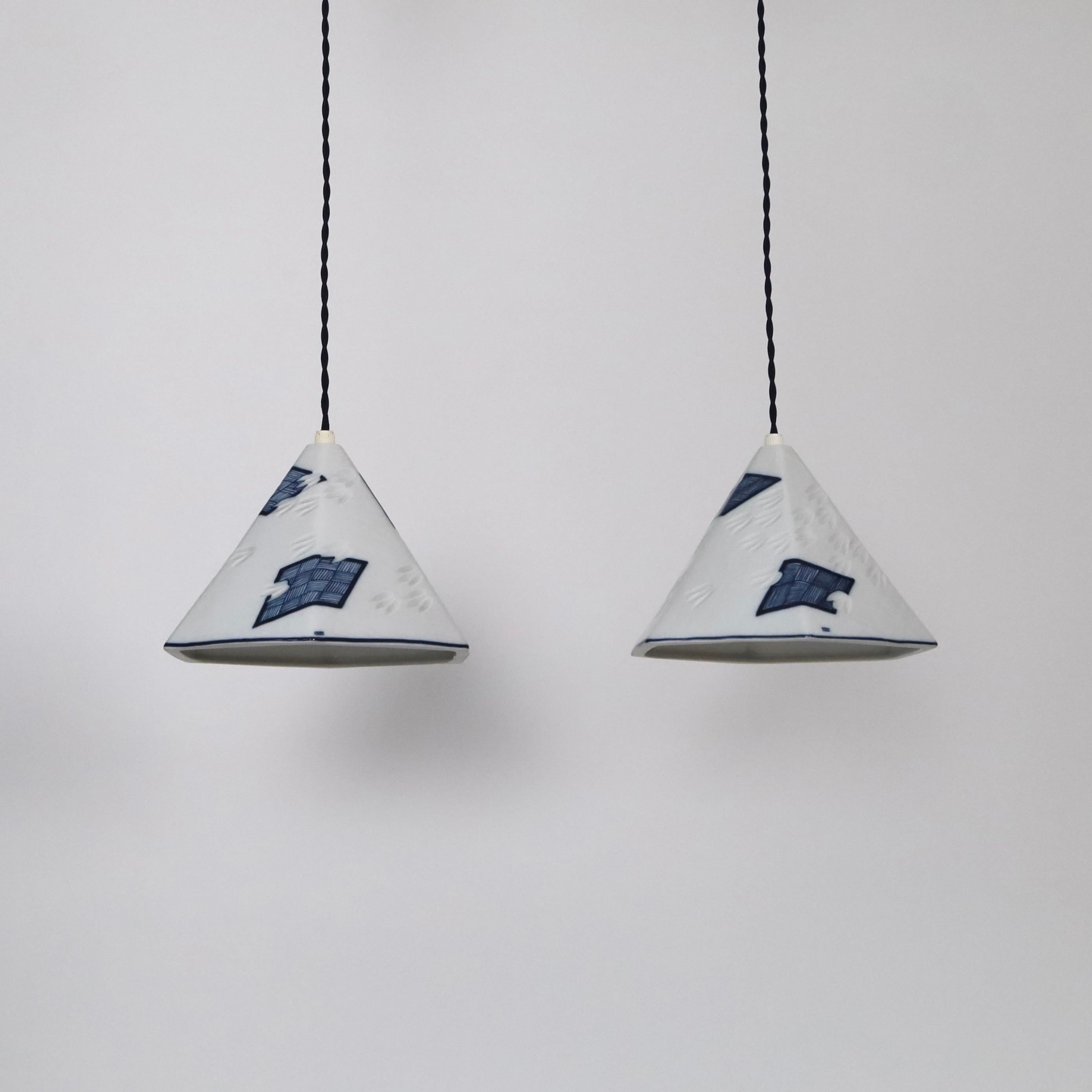 Set of Royal Copenhagen Porcelain Pendant lights by Anne Marie Trolle. An extraordinary set in great vintage condition. 

* Set (2) of white 6-sided porcelain pendant lights with dark blue drawings 
* Designer: Anne Marie Trolle
* Model: Luciana
