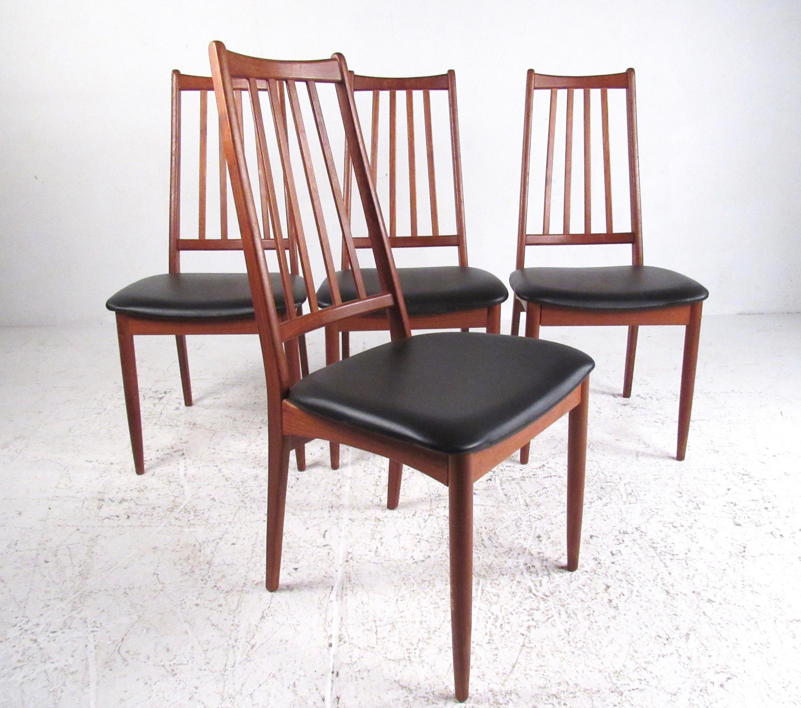 This stylish set of four Mid-Century Modern dining chairs features shapely spoked seat backs and with padded vinyl seats. Comfortable Scandinavian Modern design makes a striking addition to kitchen or dining room interiors. Please confirm item