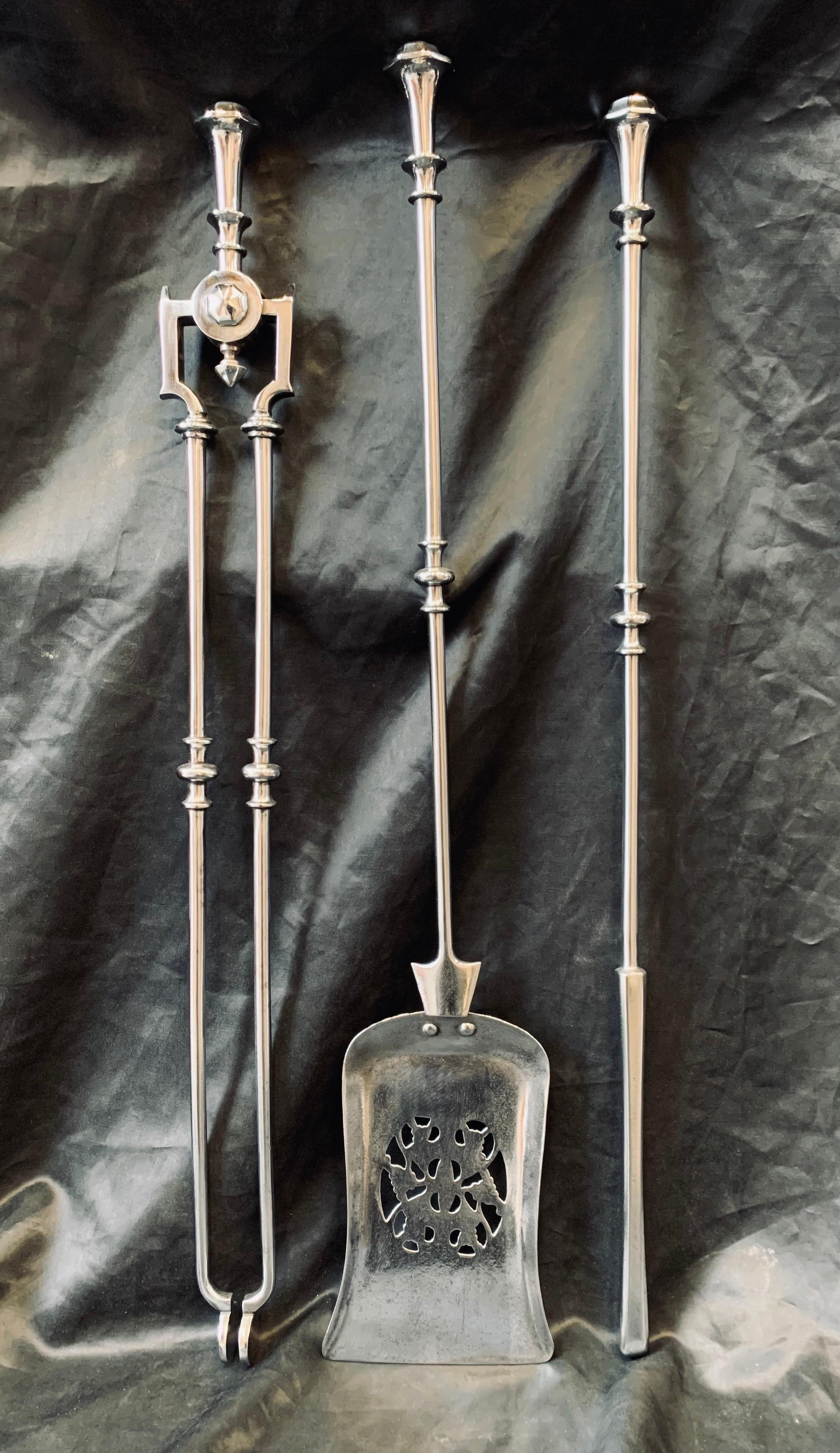 A charming set of Scottish Georgian 19th century polished steel fire iron tools. These comprise of a poker, shovel and a set of tongs. A hexagonal finial top, with a tapered polished spindle with bobbin and ball detail, the shovel blade is
