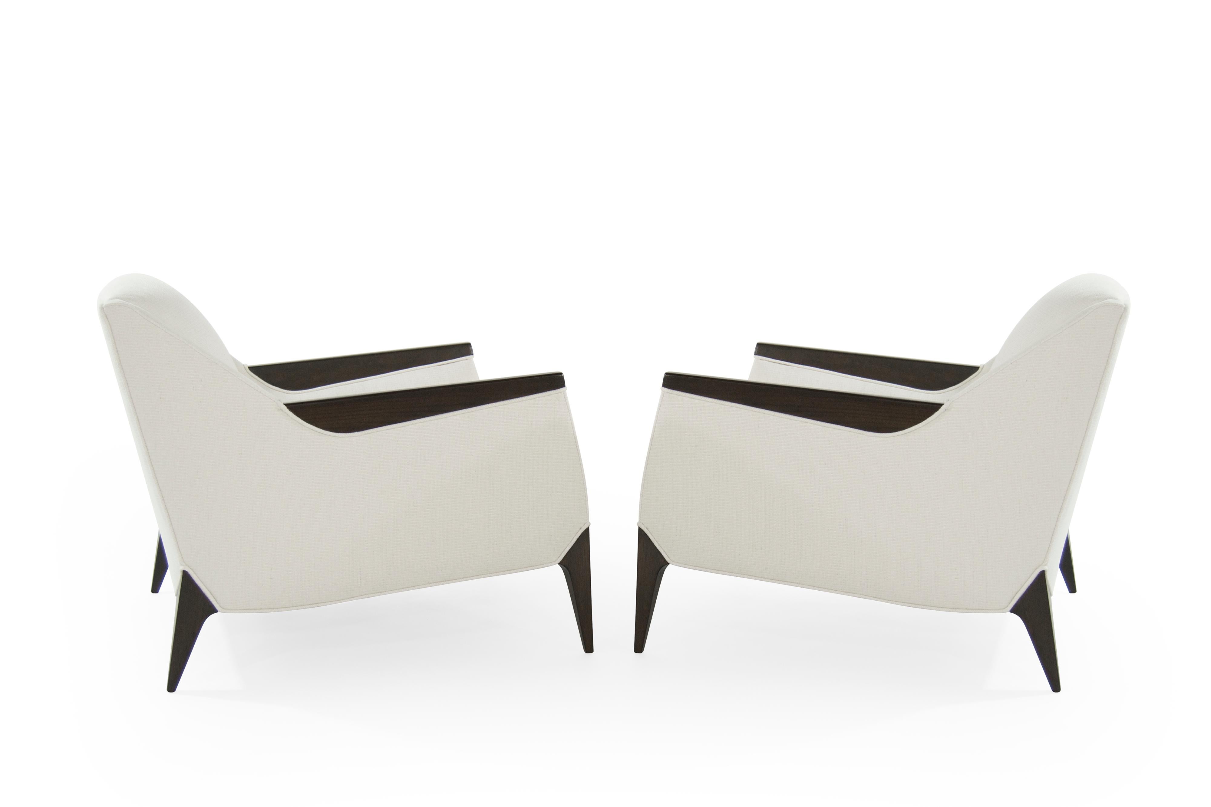 Stunning pair of sculptural Italian lounges chairs. Fully restored to their original integrity. They boast handcut high grade foam. They have been recovered in an off-white cotton/linen blend by Holly Hunt. Walnut arms and legs fully restored.