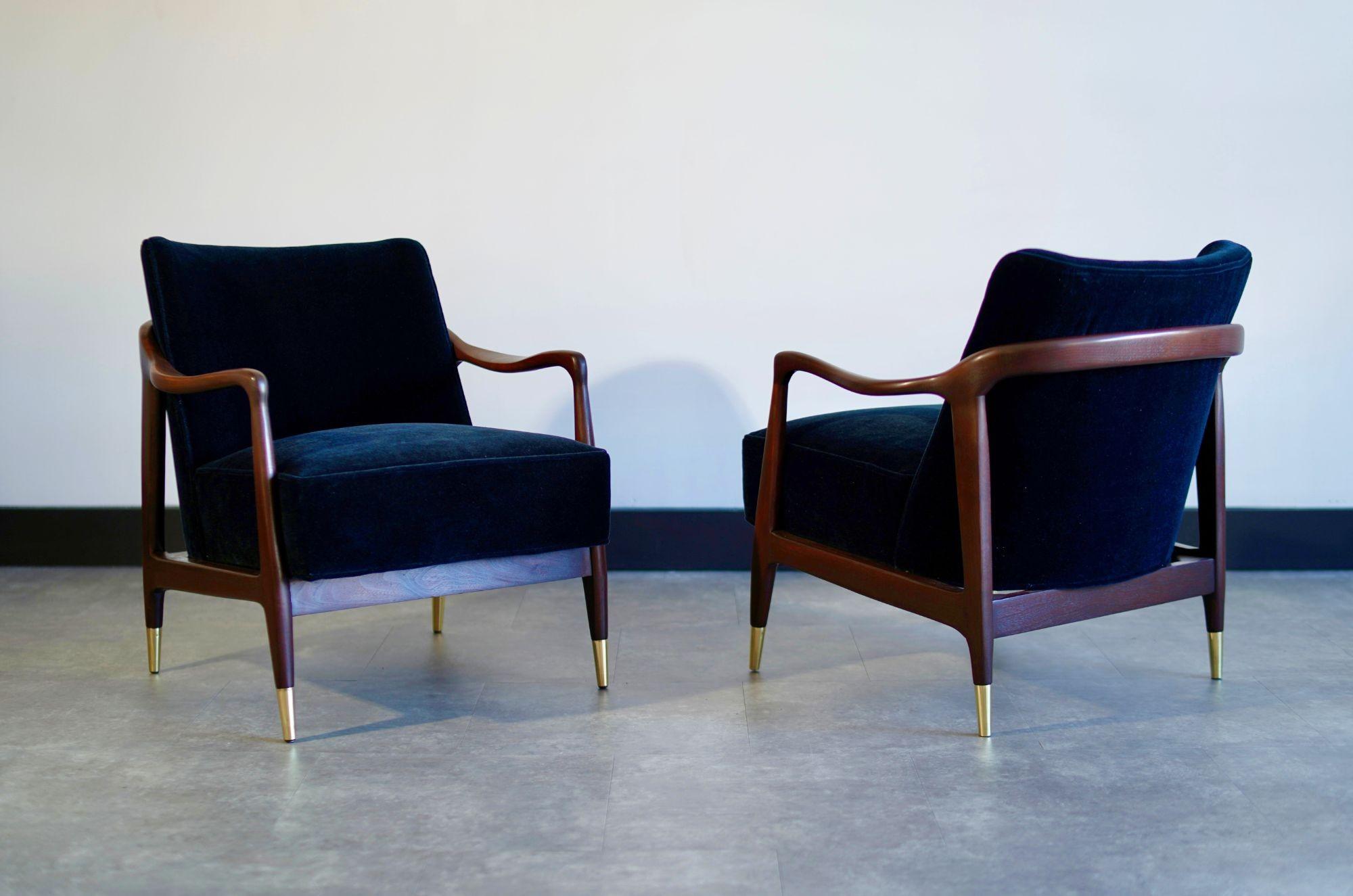 Set of vintage Gio Ponti style sculpted walnut lounge chairs, fully restored by Stamford Modern. The gorgeous walnut frames are beautifully refinished and paired with elegant brass sabots. Reupholstered in luxurious deep blue mohair, these chairs