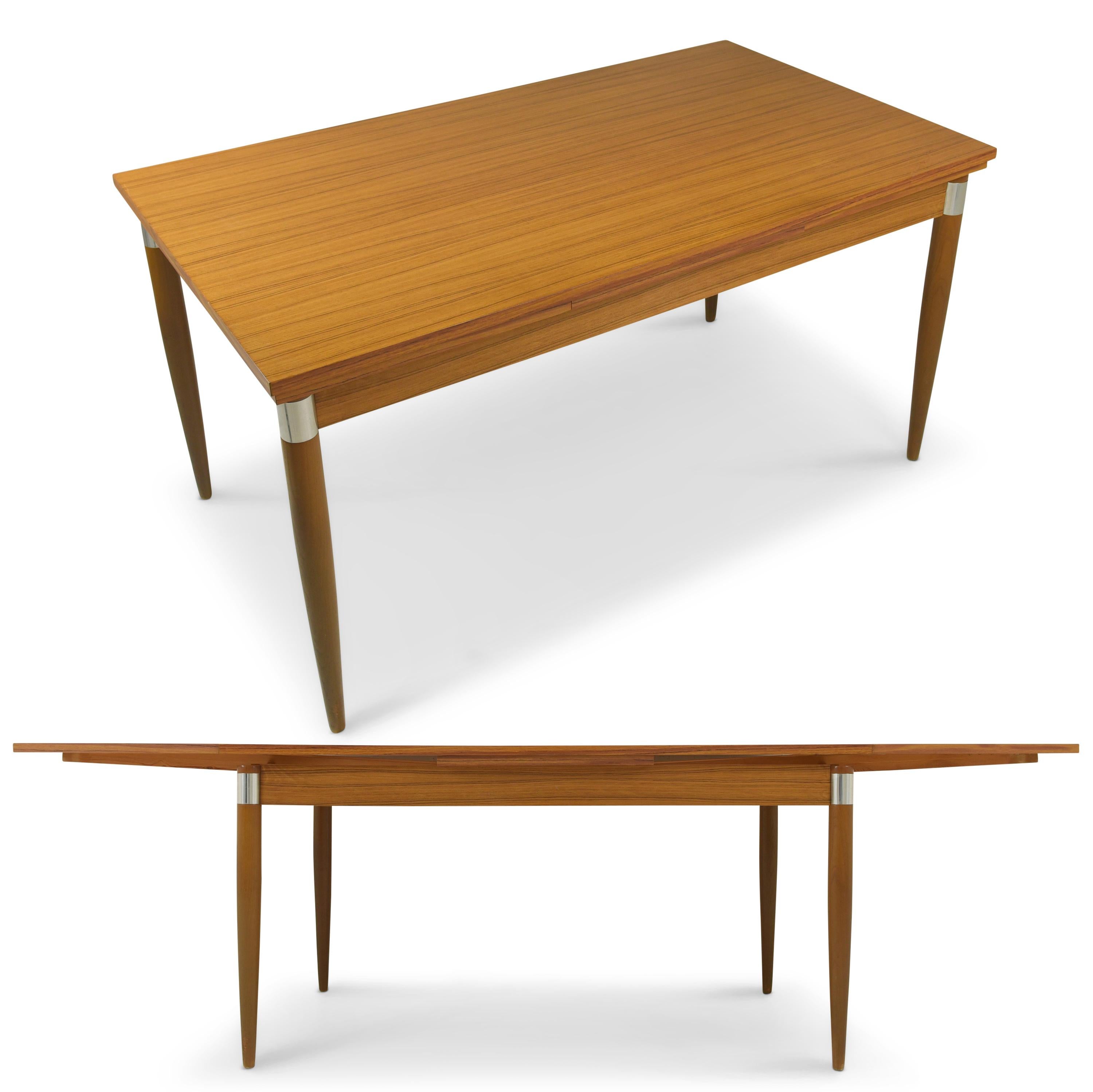 Ausziehbarer Esstisch mit 6 Stühlen restaurierte 70er Jahre Vintage Sitzgruppe

Merkmale:
Tischplatte aus Spanplatte mit dekorativer Holzfolie
Tisch mit Unterplatte, beidseitig ausziehbar von 148 cm auf 245 cm
Schwarze Sitzbezüge in gutem