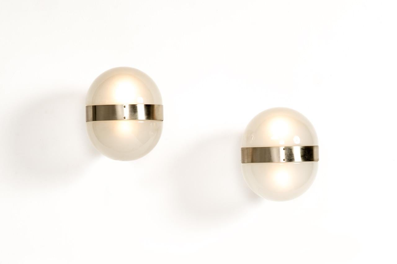 1960s Sergio Mazza 'Clio' sconce for Artemide. Executed in nickeled brass and opaline glass, Italy, circa 1960s. Clean and architectural, these hardwired sconces emit a pleasingly filtered light through its double glass shades.

Price is per item. 4