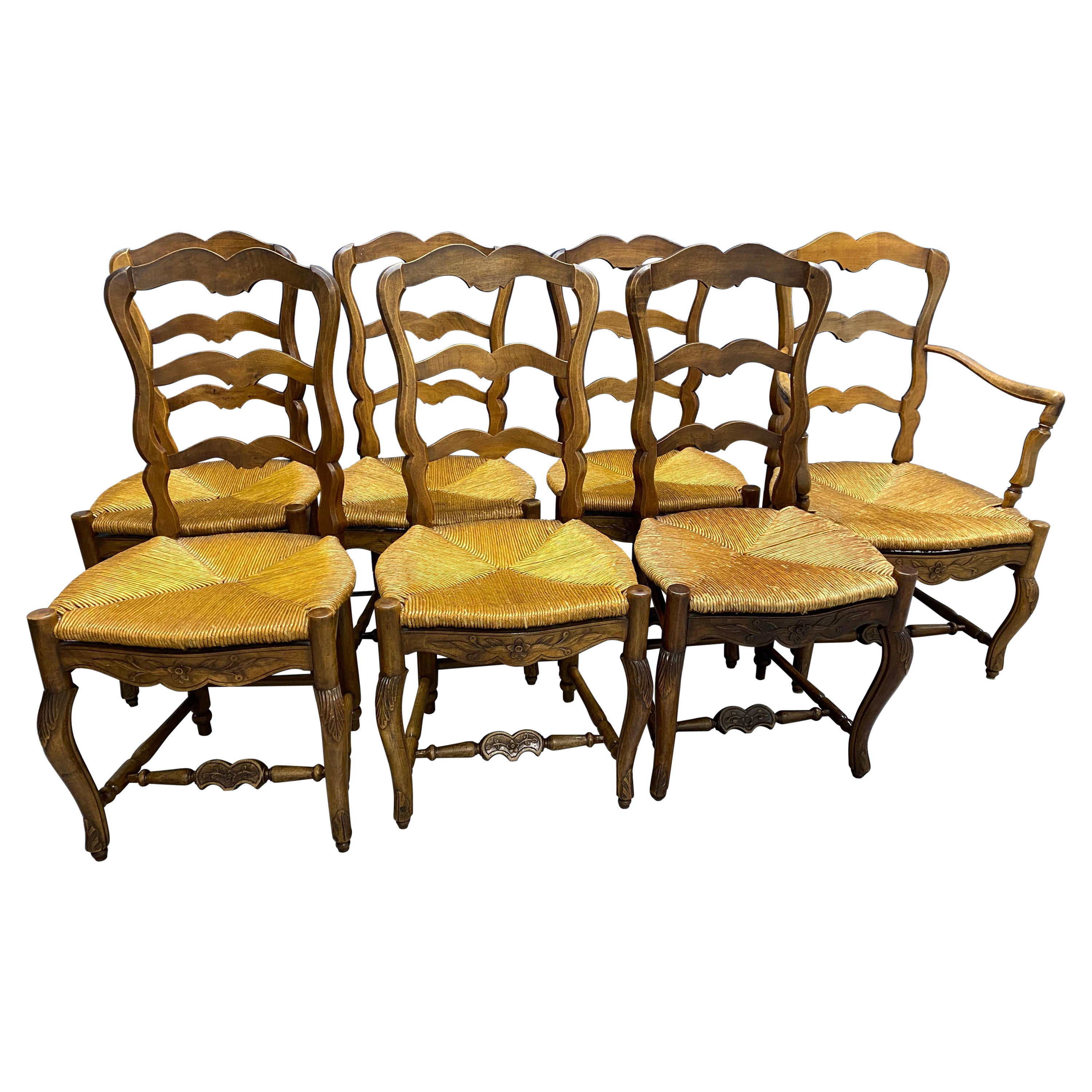 Set di sette sedie da pranzo francesi provenzali del XIX secolo con schienale a scaletta in noce e sedile in giunco
