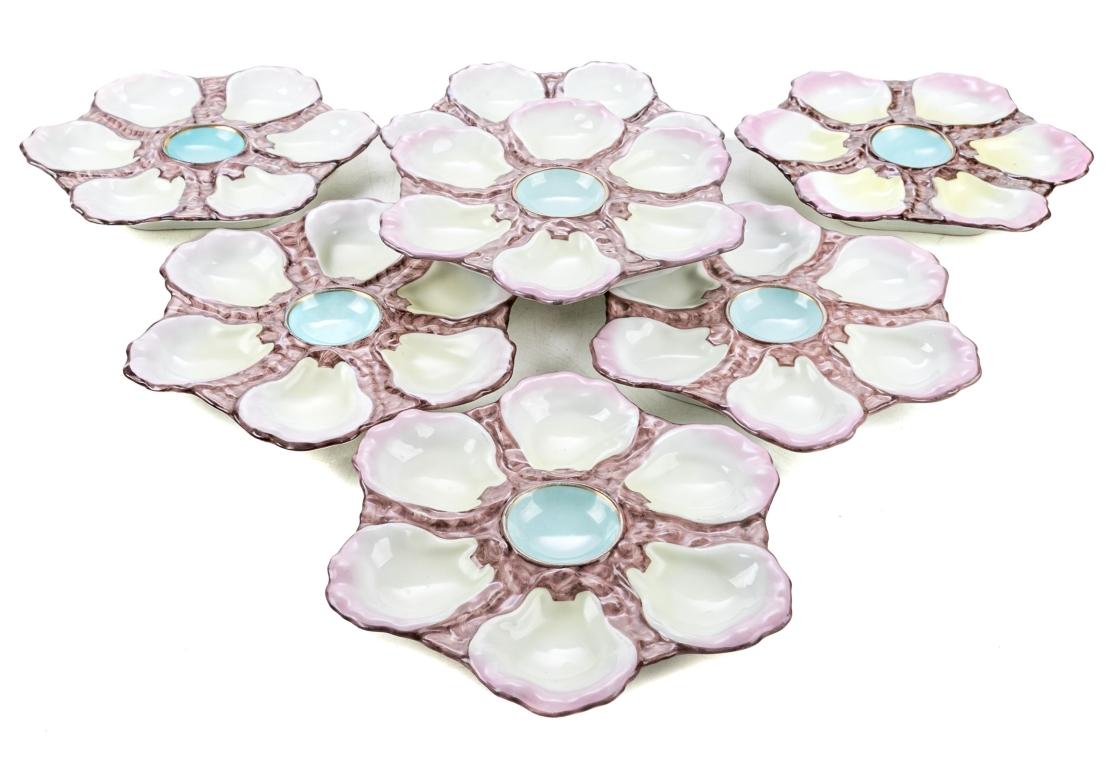 Set of 7 early antique Limoges French hand painted oyster plates. The plates with 6 pink and yellow hued compartments with a blue center well with gold trim for sauce. The plates are impressed 765 on verso and sit on a raised foot.

Dimensions: 9