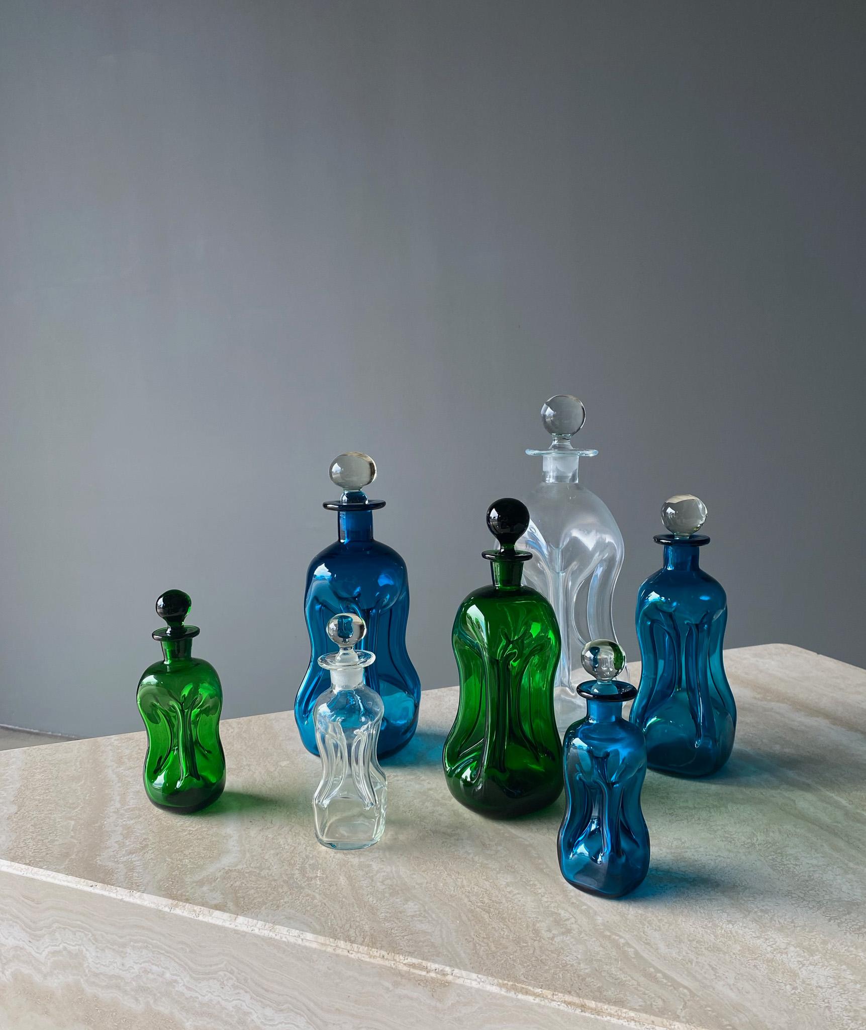 Set of Seven Art Glass Decanters by Holmegaard, Denmark, 1960s. 

Dimensions of the individual decanters are listed from largest to smallest.

1. 5 1/4'' wide by 5 1/4'' deep by 11'' tall.
2. 3 1/4'' wide by 3 1/4'' deep by 9 1/2'' tall
3. 3''