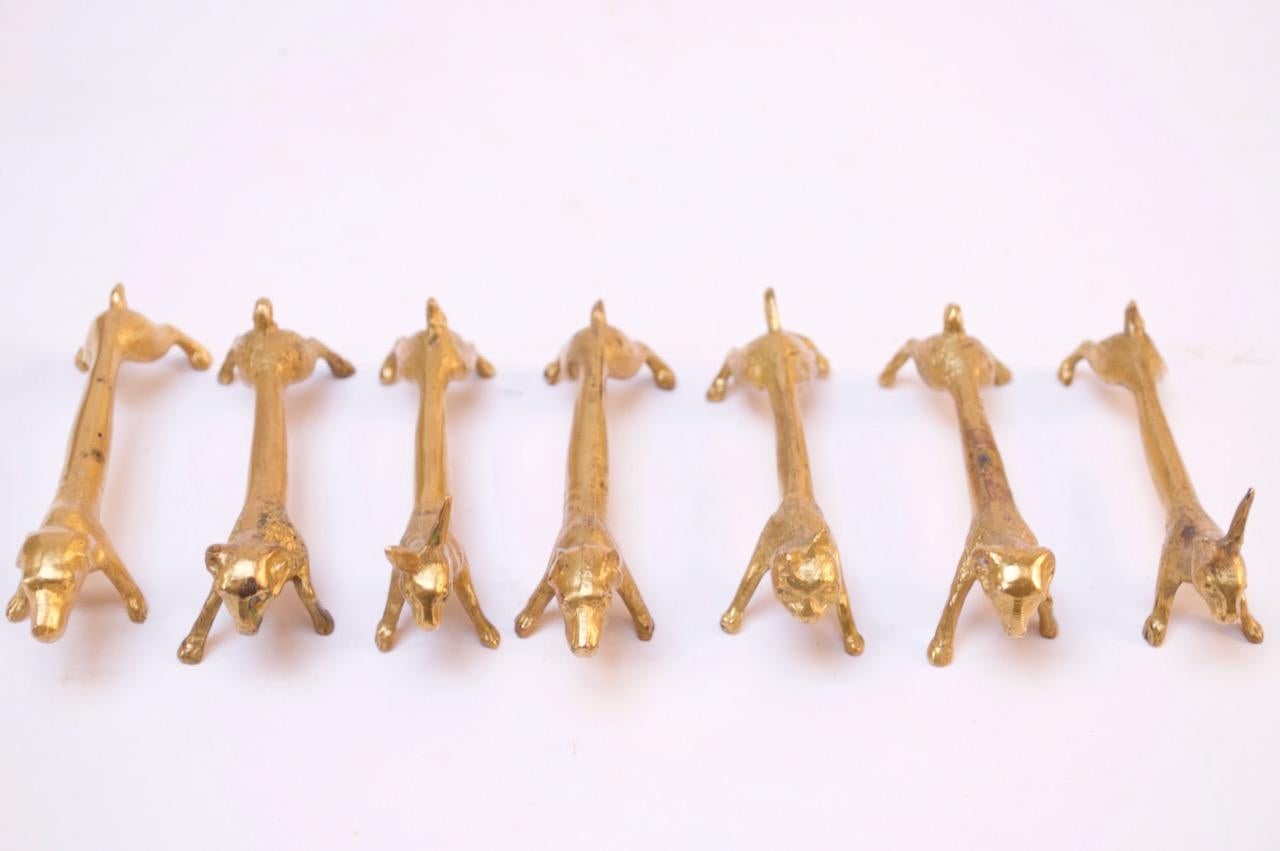Whimsical yet elegant circa 1940s animal knife rests (likely French, given their provenance) including two dogs, two rams, two rabbits, and one cat (seven in total). Composed of gilt-metal with lovely patina / wear consistent with age and use, as