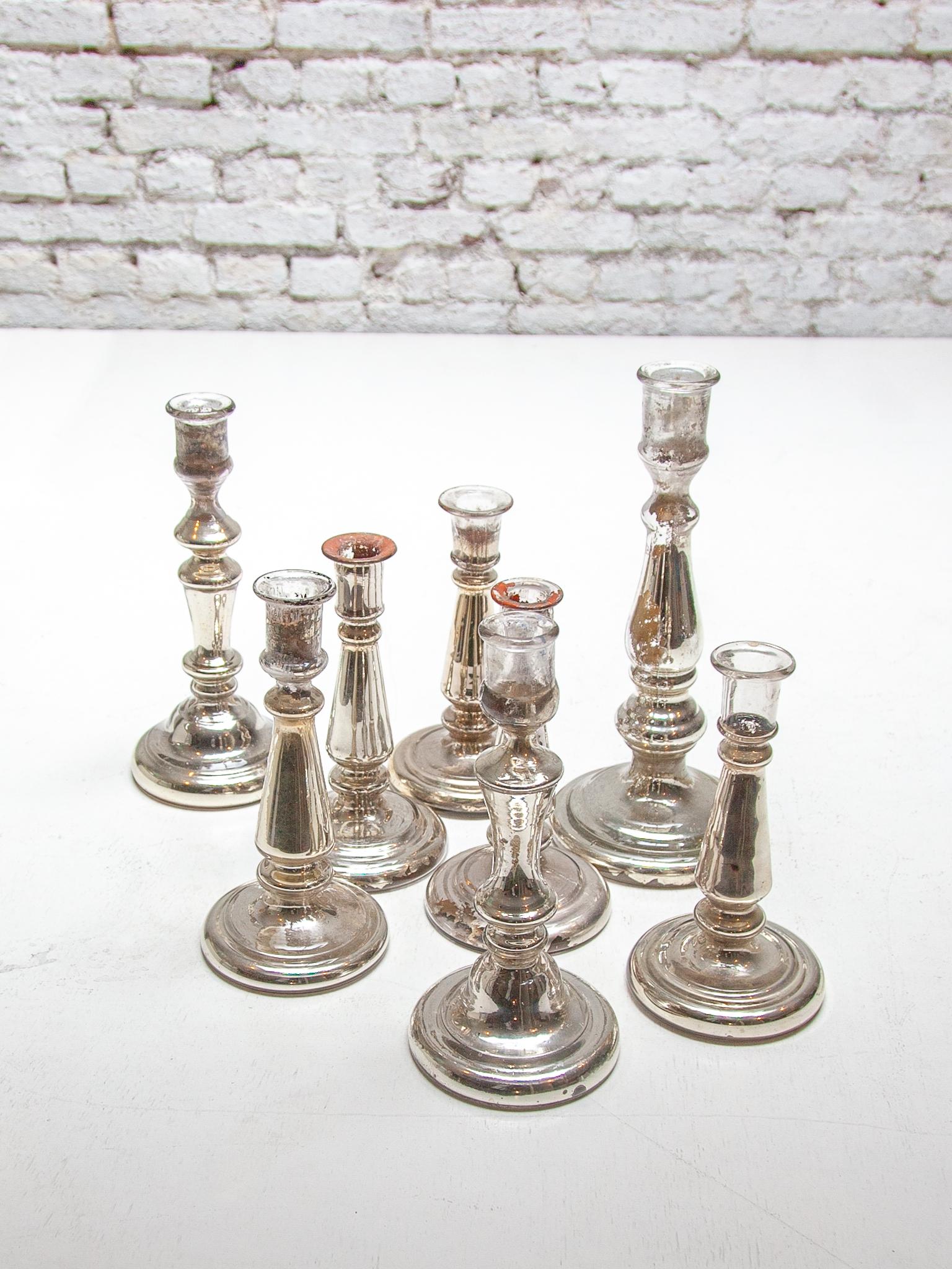 A very decorative set of seven different glass-silver candlesticks C 1900-1920. Each candlestick made of poor man's silver is made of double-walled glass that is silver-plated on the inside. Old poor man's silver is often beautifully weathered and