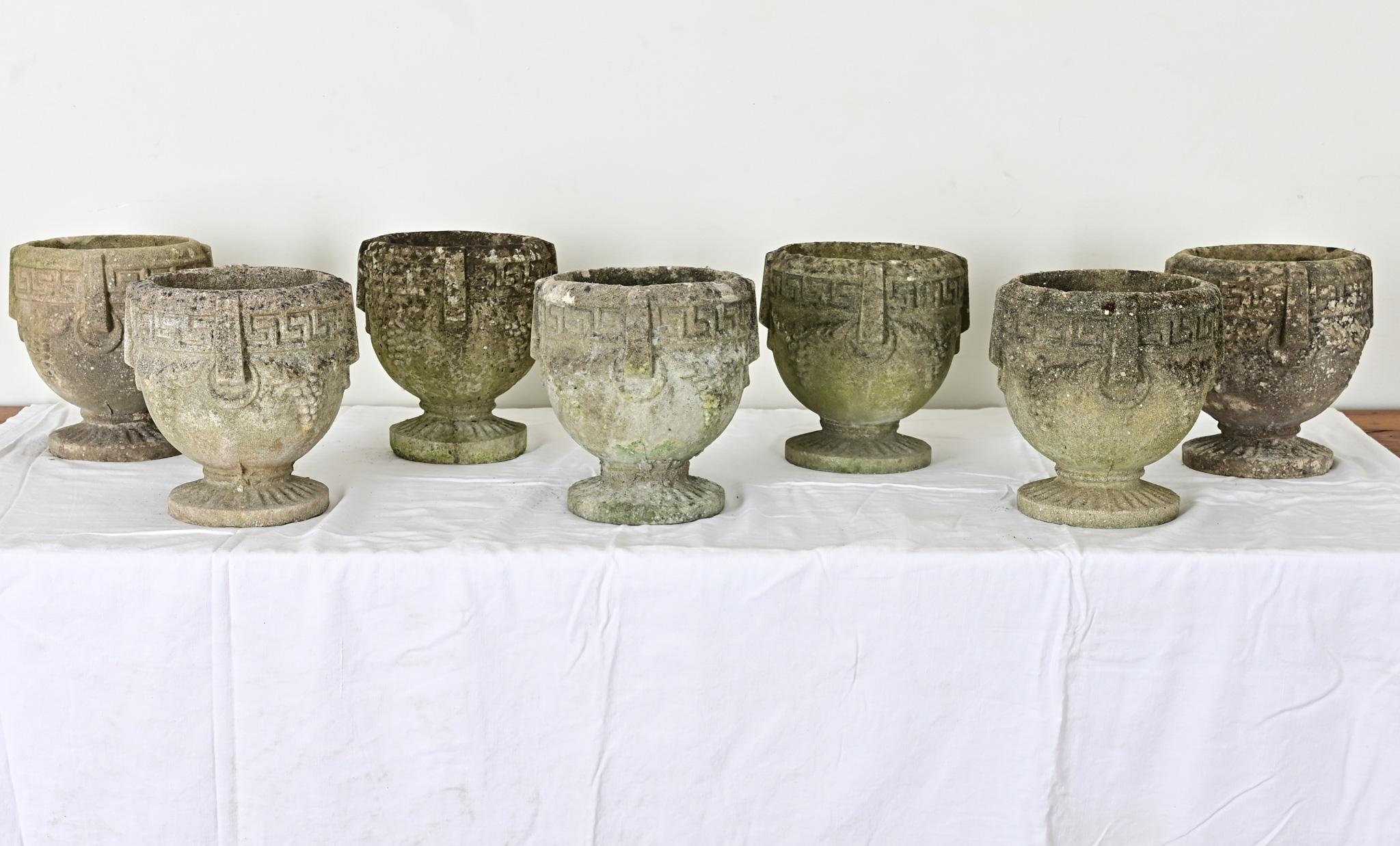 Classic and refined grouping of planters from England, in reconstituted stone, are the perfect addition to your garden or interior. Each plant pot, or cache pot, has Greek Key and grapevine decoration around the circumference, with four implied