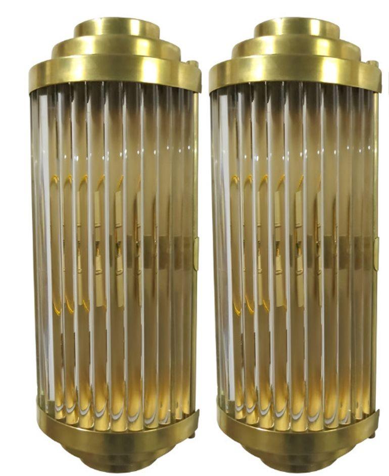 Elegant ensemble de sept appliques murales Romano vintage, chacune présentant des tubes en cristal clair montés sur des cadres en laiton poli. Fabriqués en Italie dans les années 1980, ces luminaires intemporels associent des matériaux raffinés à