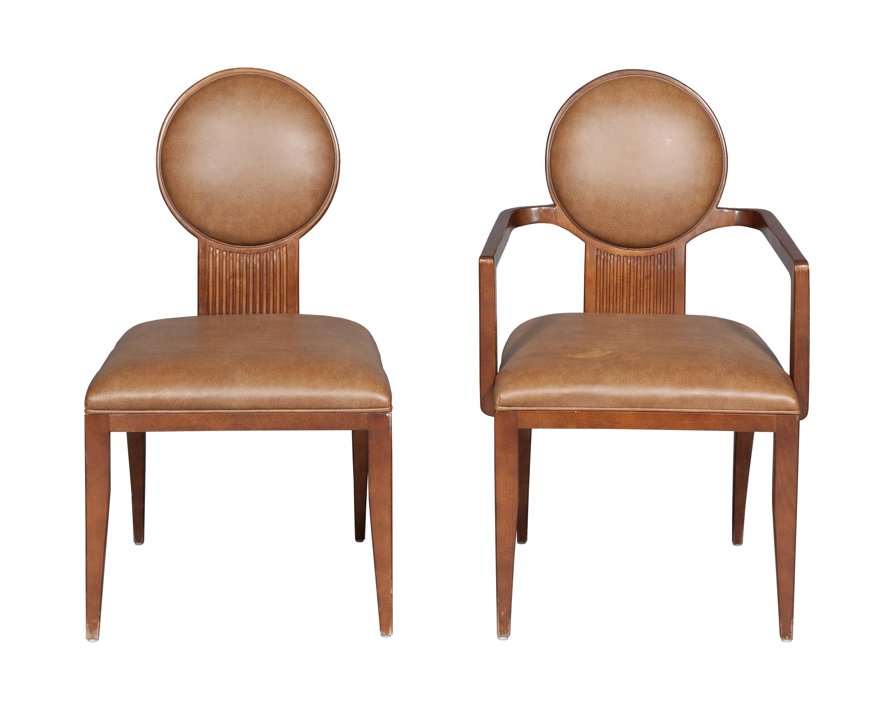 Set of seven dinnign chairs comprising a pair of armchairs and five side chairs. Design by Juan Montoya, these unique chiars have a circular faux leather upholstered backrest above a reeded splat and conforming seat, on tapered legs. 

Armchair