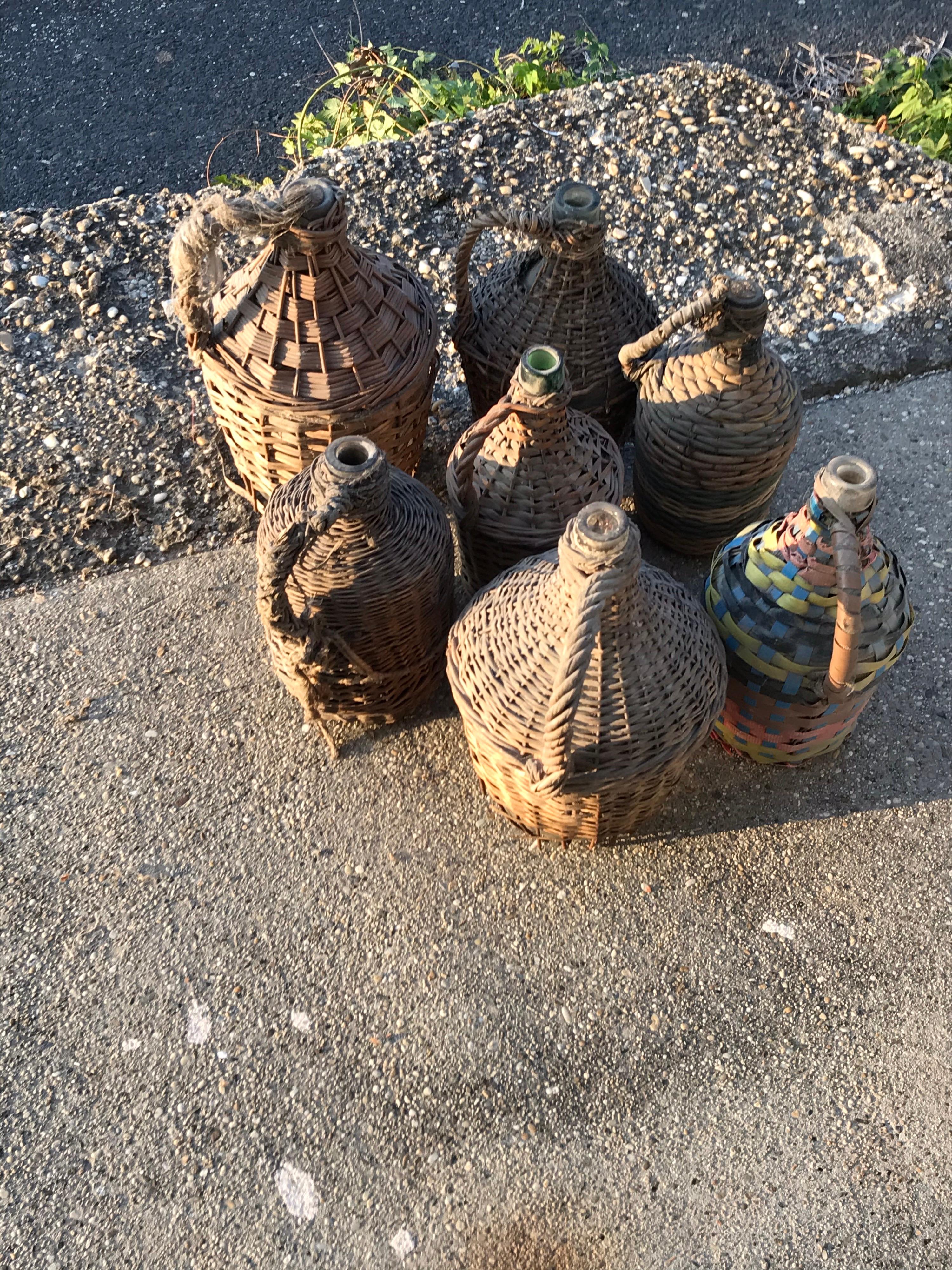 Rustic Set of Seven Midcentury Vintner Woven Baskets with Demijohn Wine Bottles For Sale