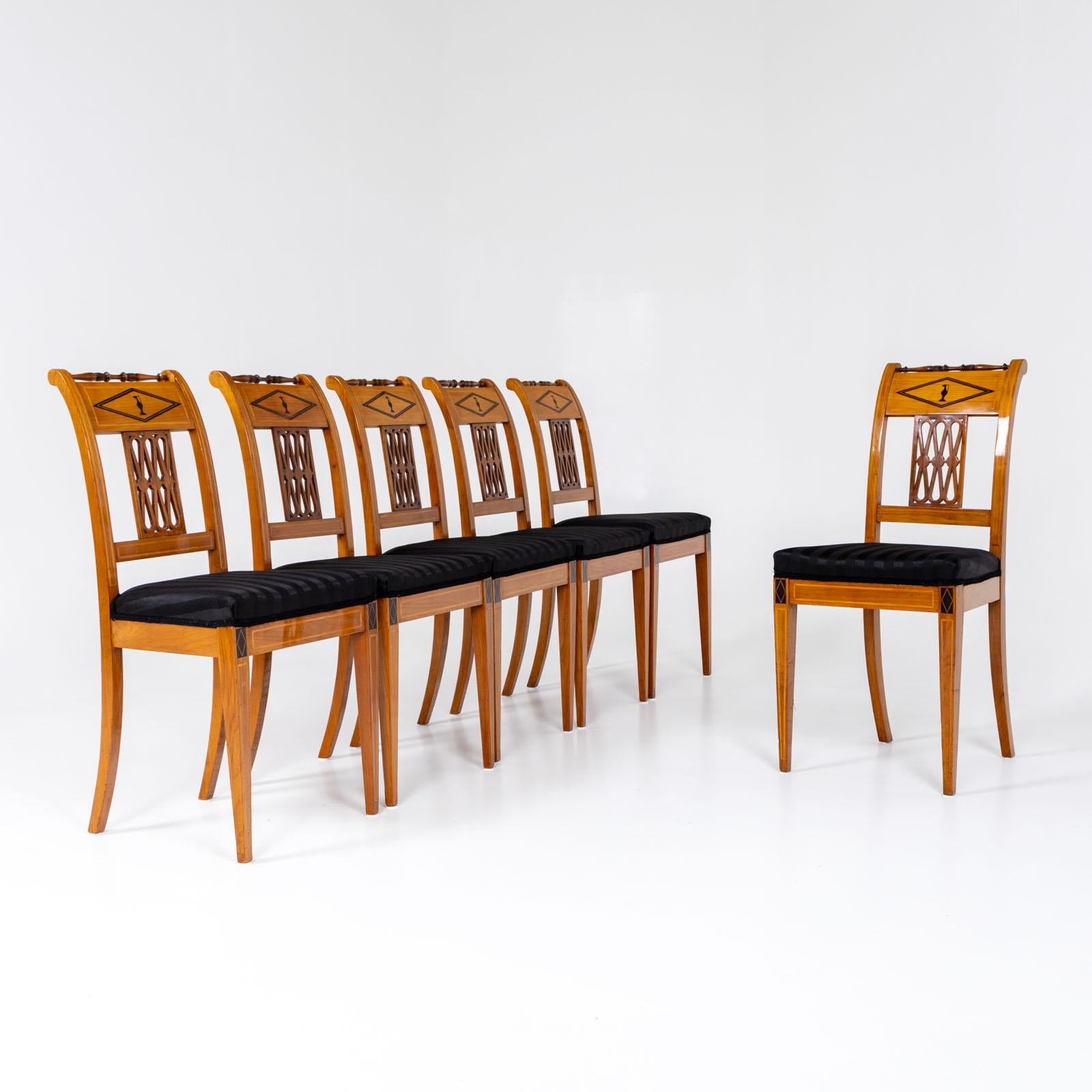 Set di sei sedie da pranzo e una poltrona su alte ed eleganti gambe quadrate affusolate con intarsi a filetto. Le gambe posteriori sono leggermente svasate e, insieme agli schienali arrotondati, conferiscono alle sedie una curva elegante. Gli