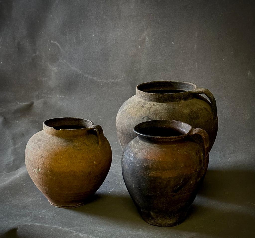 Romanian cooking pots. A standard household item in turn of the century Romanian territories, these large terracotta vessels were used for both cooking and food storage. Their generous shape and rustic patina make them beautiful decorative accent