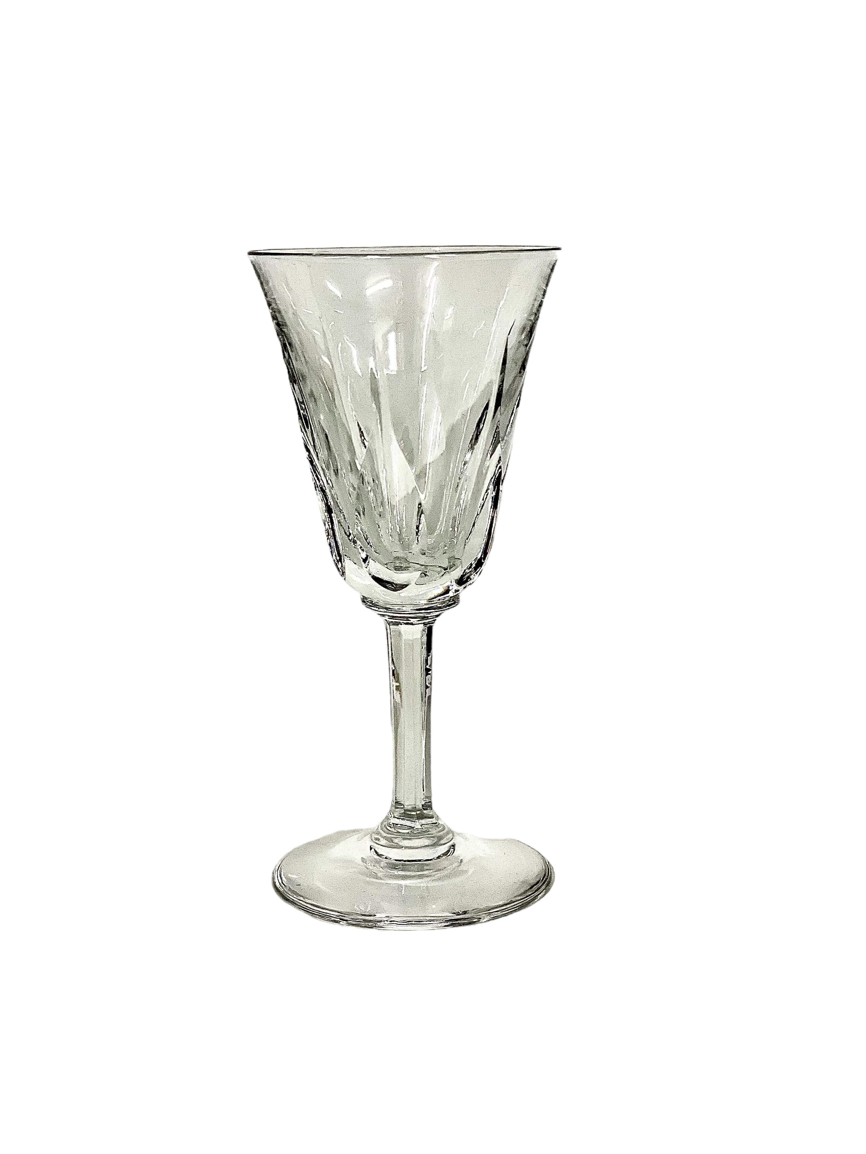 An exceptional set of 7 crystal water glasses in sparkling Saint-Louis crystal. The tulip-shaped chalice of each is cut with tall and pointed lozenges, while the stem features elegantly cut flat ribs. The glasses are all stamped 'Saint-Louis' under