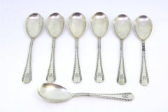 Set of seven silver ice cream scoops with grooves along the handles