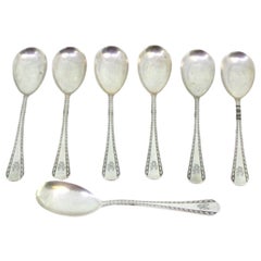 Set of seven silver ice cream scoops with grooves along the handles