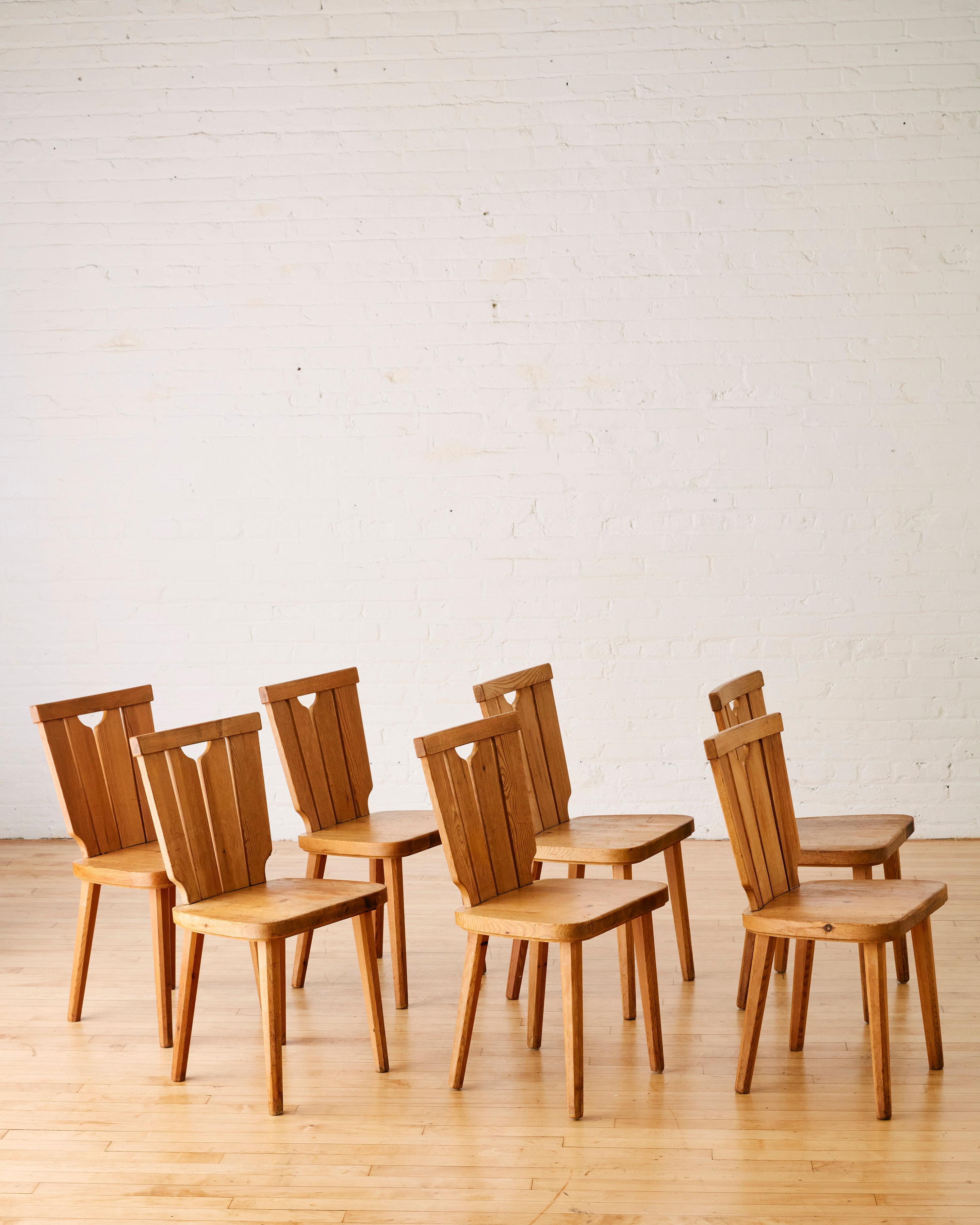 A set of seven Swedish pine dining chairs by Goran Malmvall featuring a slatted back rest. 

Göran Malmvall (1917-2001), was born into the furniture & design industry. As the youngest son of the founder Karl Andersson of Karl Andersson & Sons/Söner.