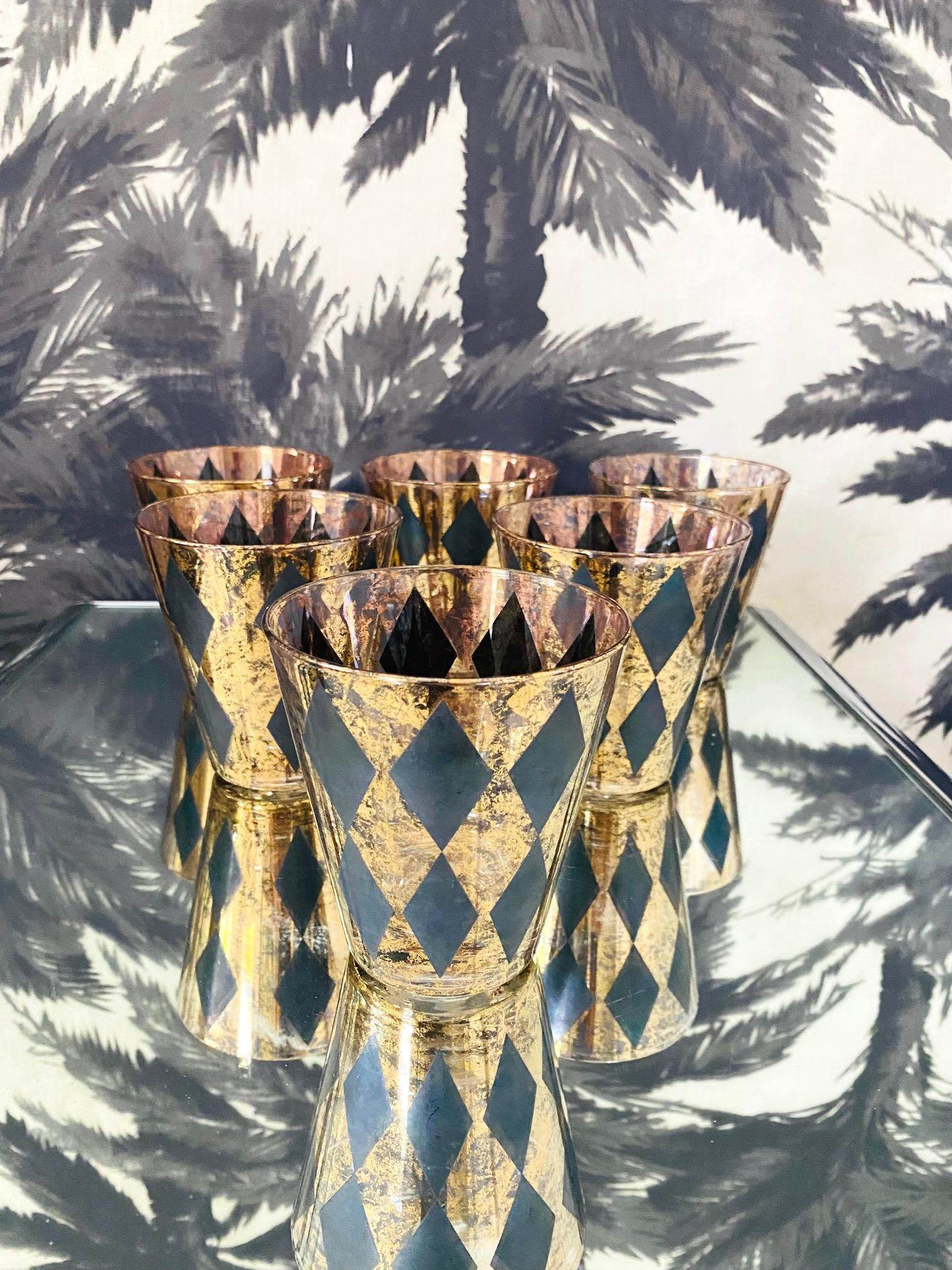 1960's Hollywood Regency whiskey rock glasses with Harlequin design. Cocktail set includes six handblown glasses with tapered forms featuring black diamond patterns over clear glass with 22-karat gold leaf flecks throughout.  Makes a chic addition