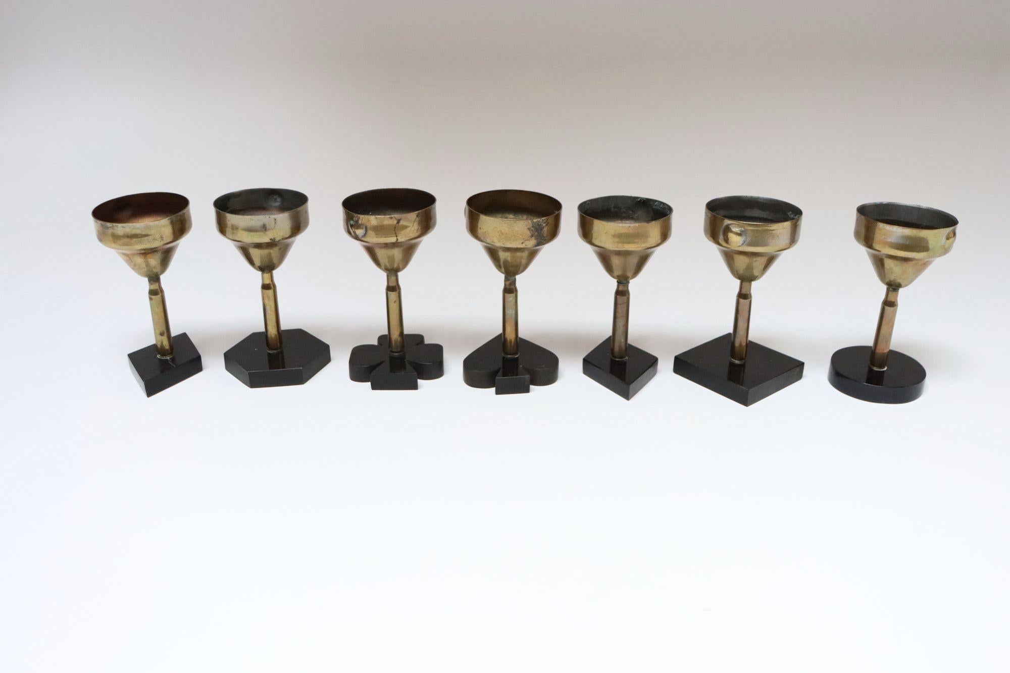 Unique set of seven diminutive trench art goblets in brass (circa 1930s, USA).
Formed from artillery shell stems supported by black bakelite bases.
Bases are both card suit-forms (two diamonds, one clover and one spade) in addition to one circle,