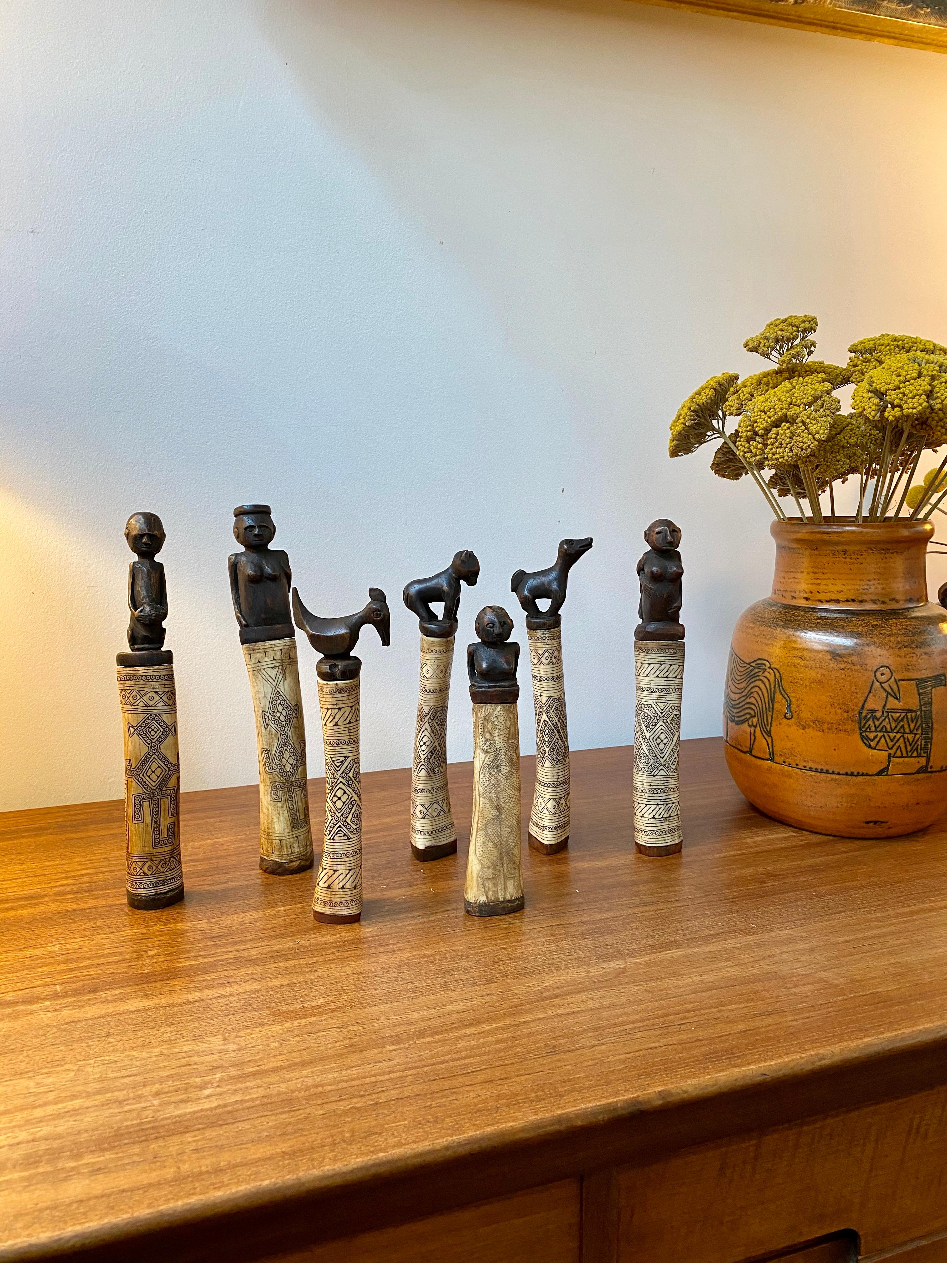 Set of seven wood and bone lime powder holders for betel nut from West Timor Island, Indonesia (circa 1940s-1960s). These beautiful receptacles are made of bone with incised traditional decoration and beautifully carved wooden stoppers in the form