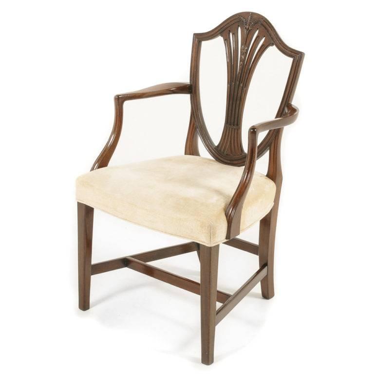A set of eight carved mahogany Sheraton-Revival shield back dining chairs, consisting of six side chairs and two armchairs, the backs with pierced splats and wheat sheaf carving. Striking design and sturdy enough for everyday use, circa