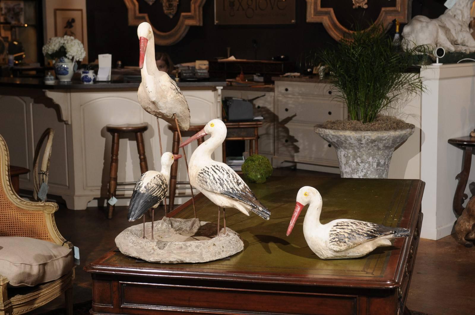 A set of Sicilian lifesize painted stone shorebird sculptures from the early 20th century. This set of shorebirds comprises a central stone bowl on which are mounted three birds, as well as a single bird that can be placed on the side. The rugged