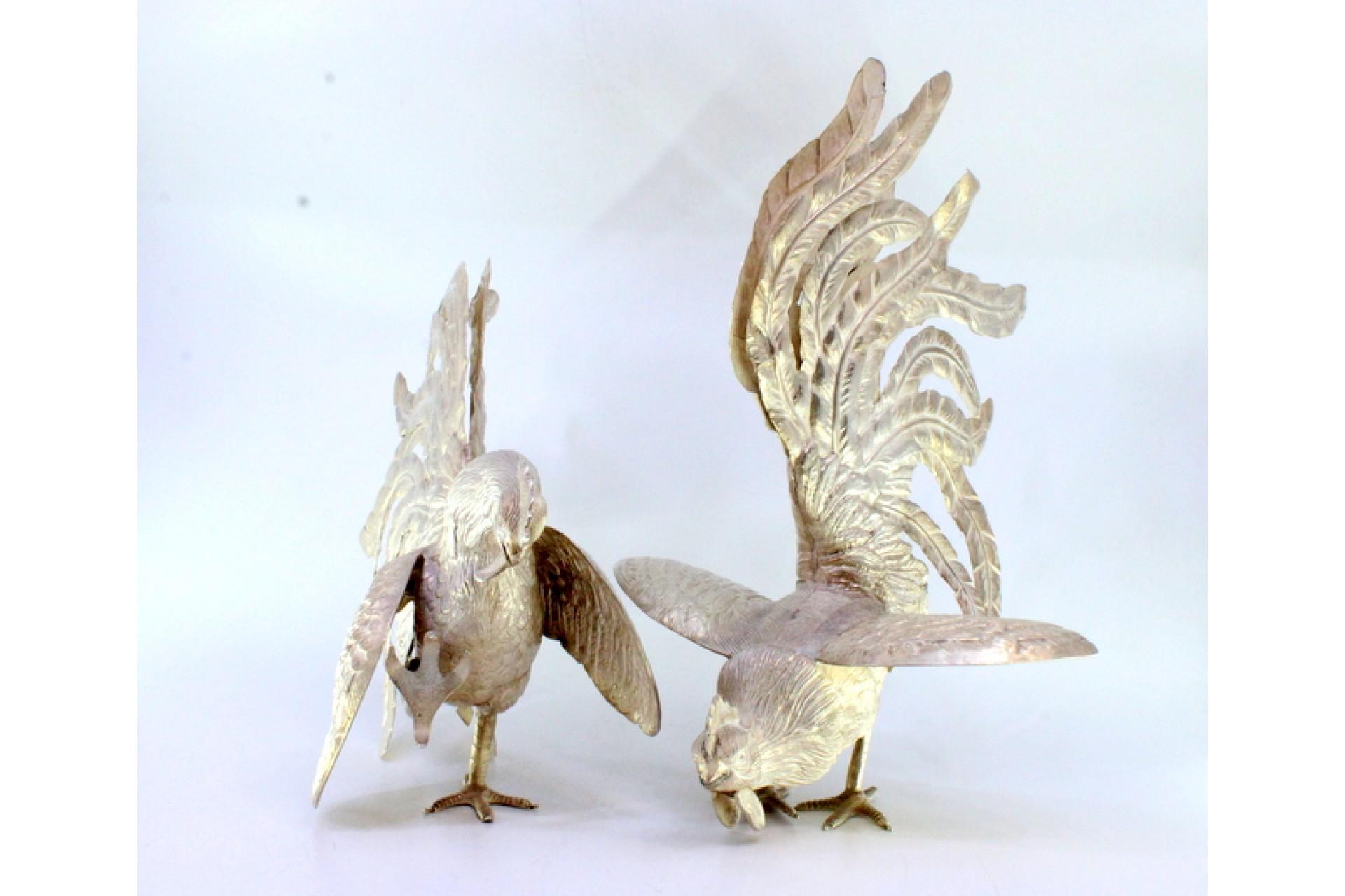 Descripción: Conjunto de gallos de pelea de plata con relieves y aplicaciones. Metal: Silver. Origen: Español. Marca: Desconocida. Peso: 913,59 gramos (Conjunto de gallos). Dimensiones: Gallo 26,5x18cm Gallo 28x19,5cm. Contenido: . Marca de ensayo: