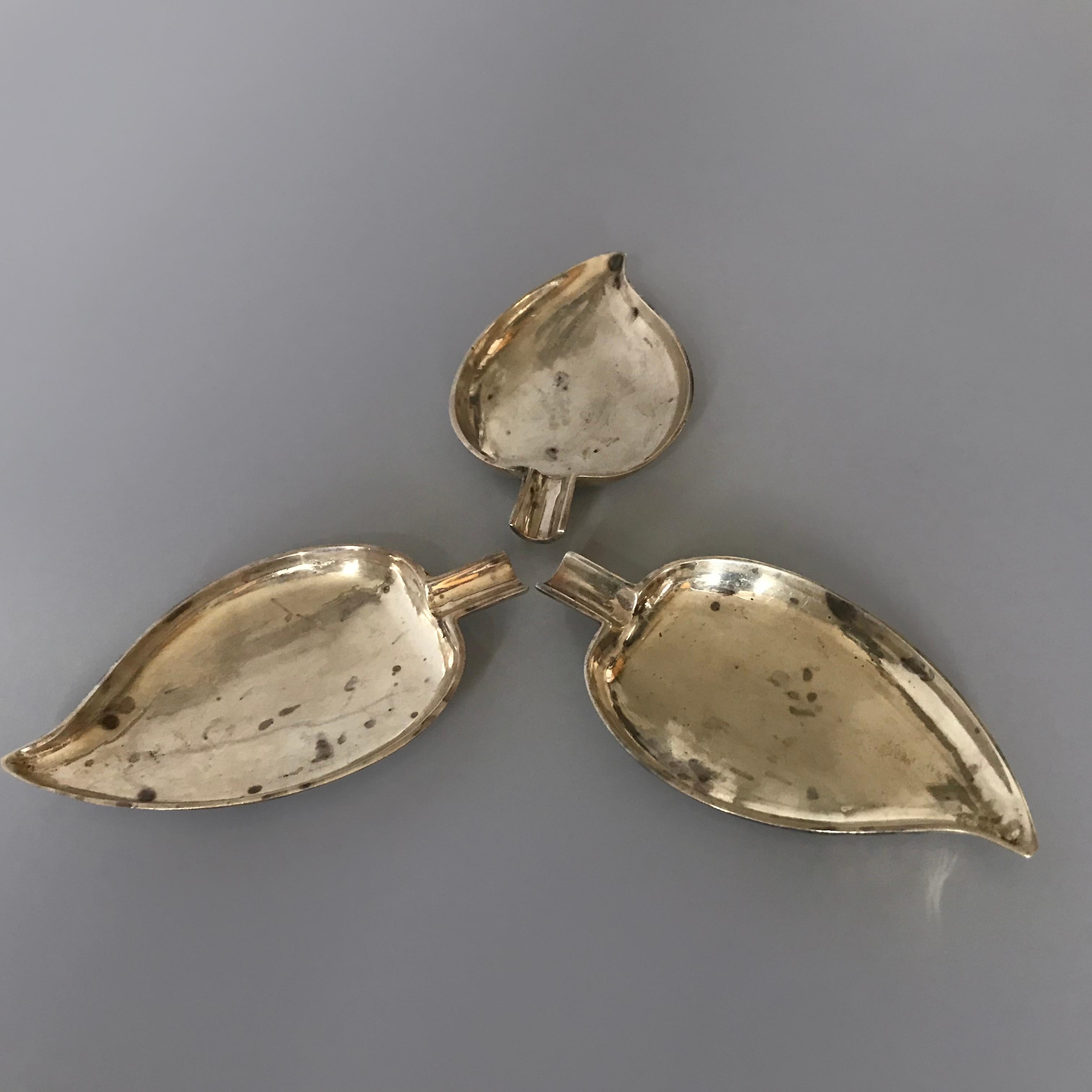 Ensemble de trois élégants plats en forme de feuilles avec tiges en métal argenté lourd des années 1940. Estampillé au dos.