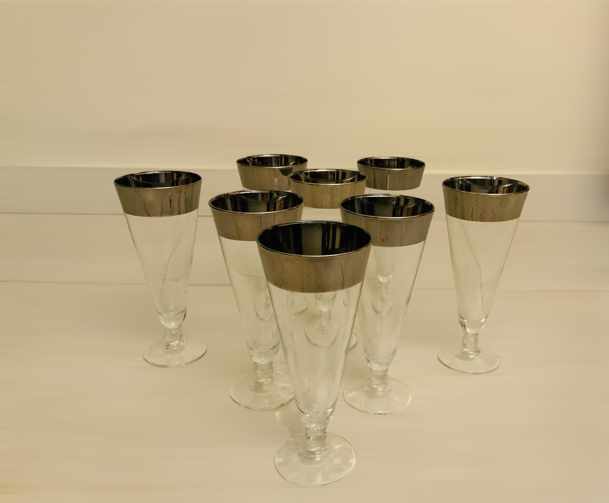 This is a set of eight silver rimmed clear glass long cone shaped beer Pilsner glasses.