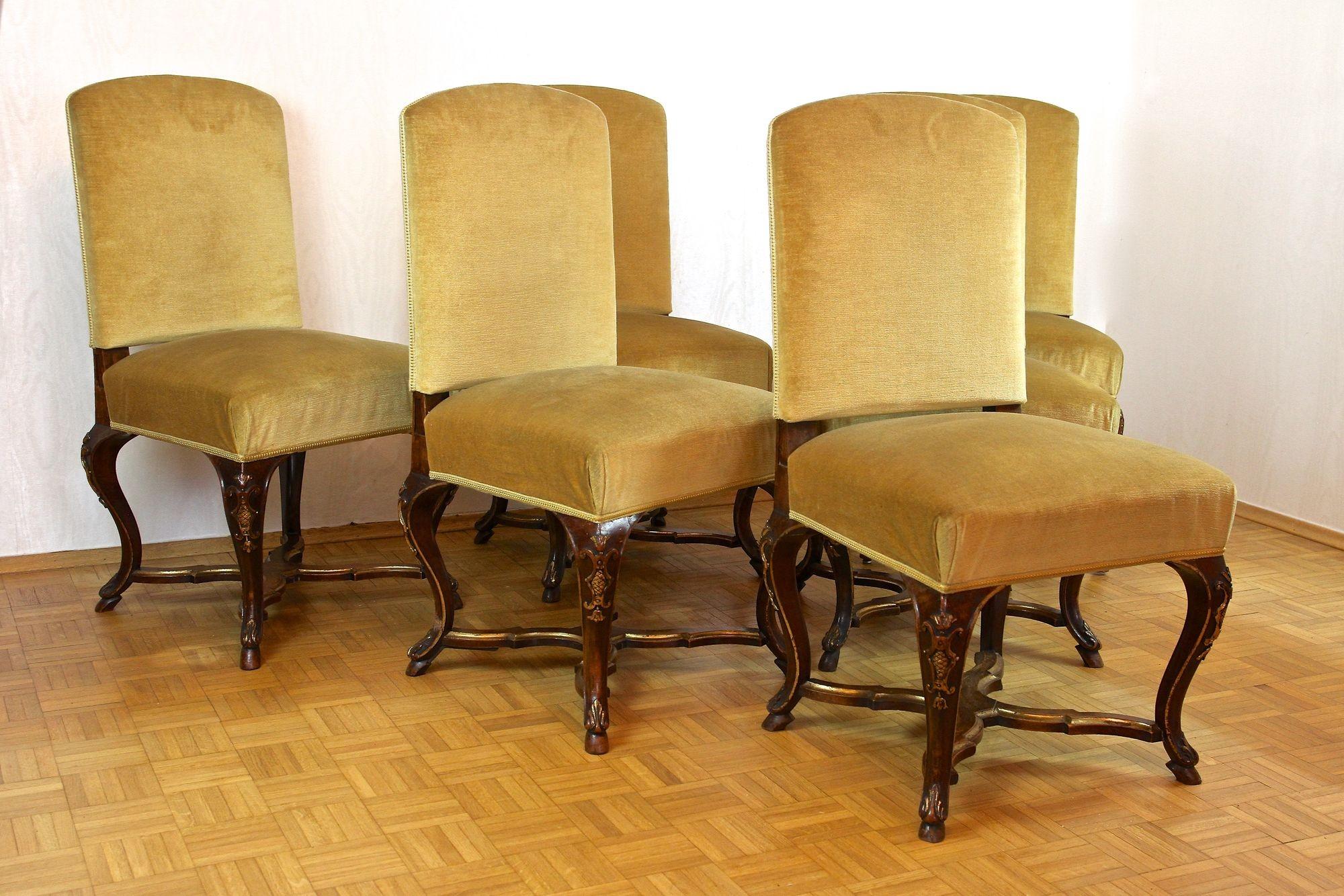 Exquisite set of six handcarved baroque dining chairs from the late period around 1790 in Italy. These stunning Italian baroque chairs were elaborately handcrafted out of solid oakwood and trimmed to a very dark nutwood tone. The elegantly curved