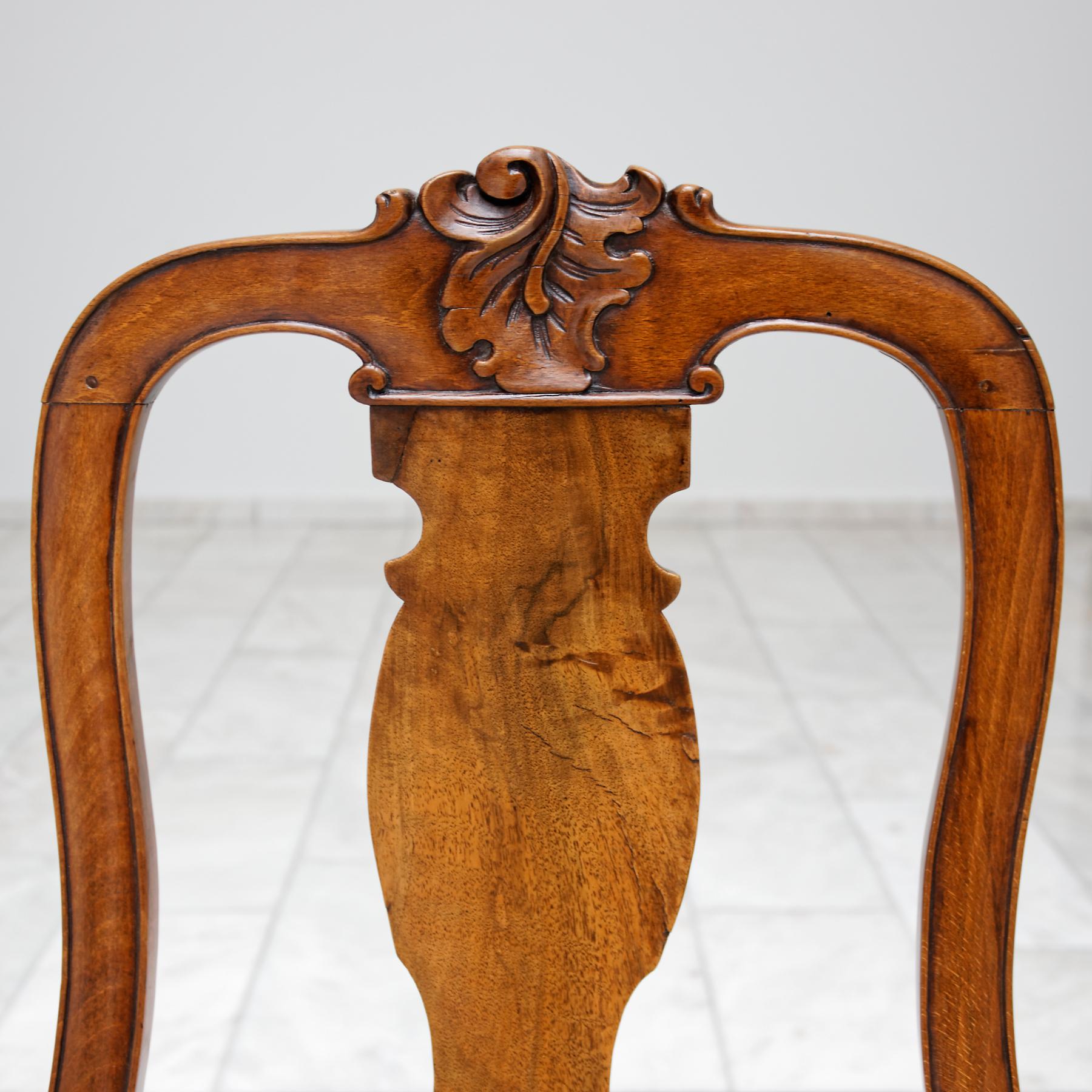 Set of six 18th century German Baroque walnut dining chairs, probably from Saxony. With baluster shape splat and drop in seat covered in yellow silk (modern). The seat rail and back with central carved foliate spray and acanthus leave. On cabriole