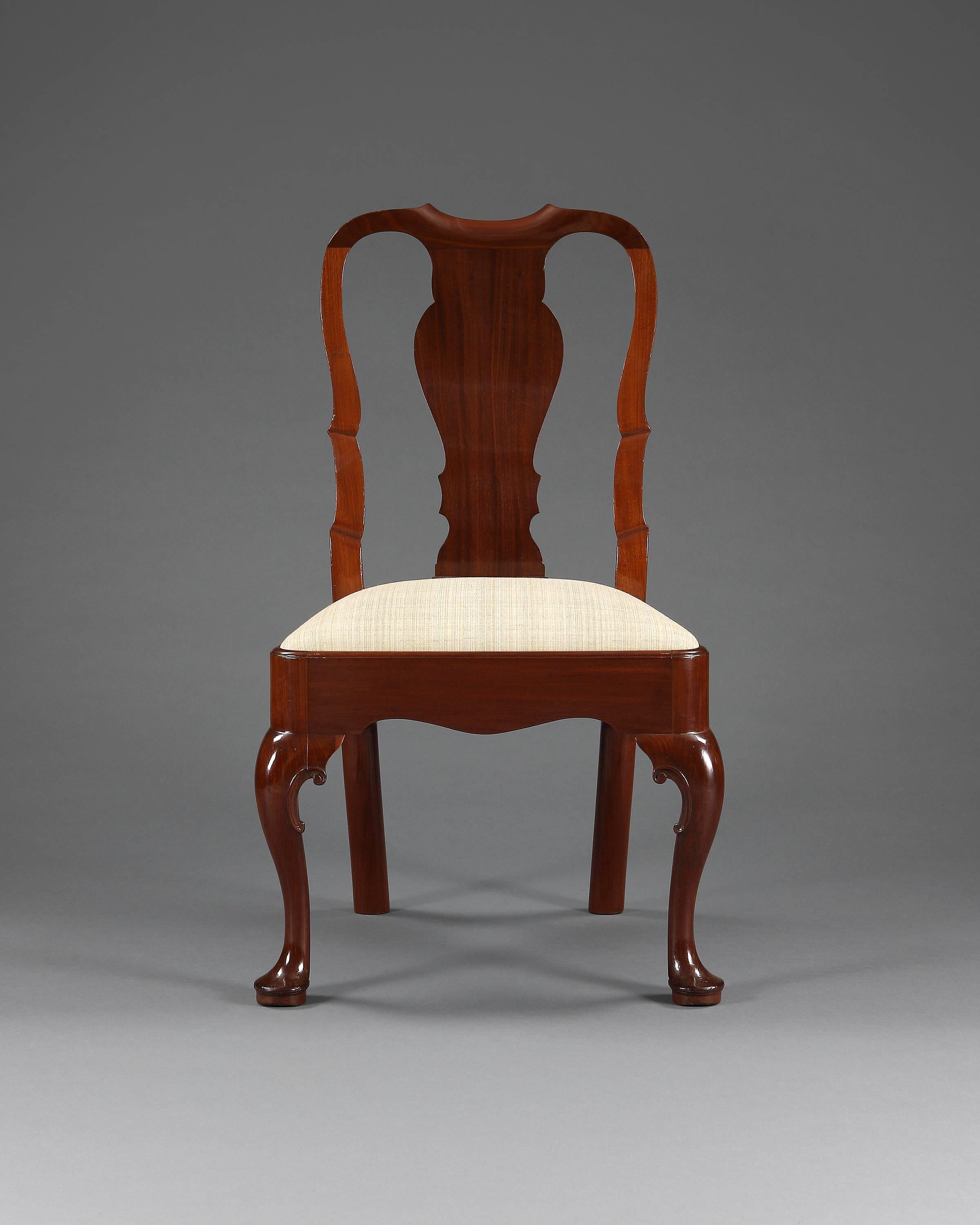 Six George II, 18th century mahogany high back dining chairs. Each having a drop-in seat, vase shape back splat. The front cabriole legs are raised on pad feet with C-scroll motif to the knees, English, circa 1705.